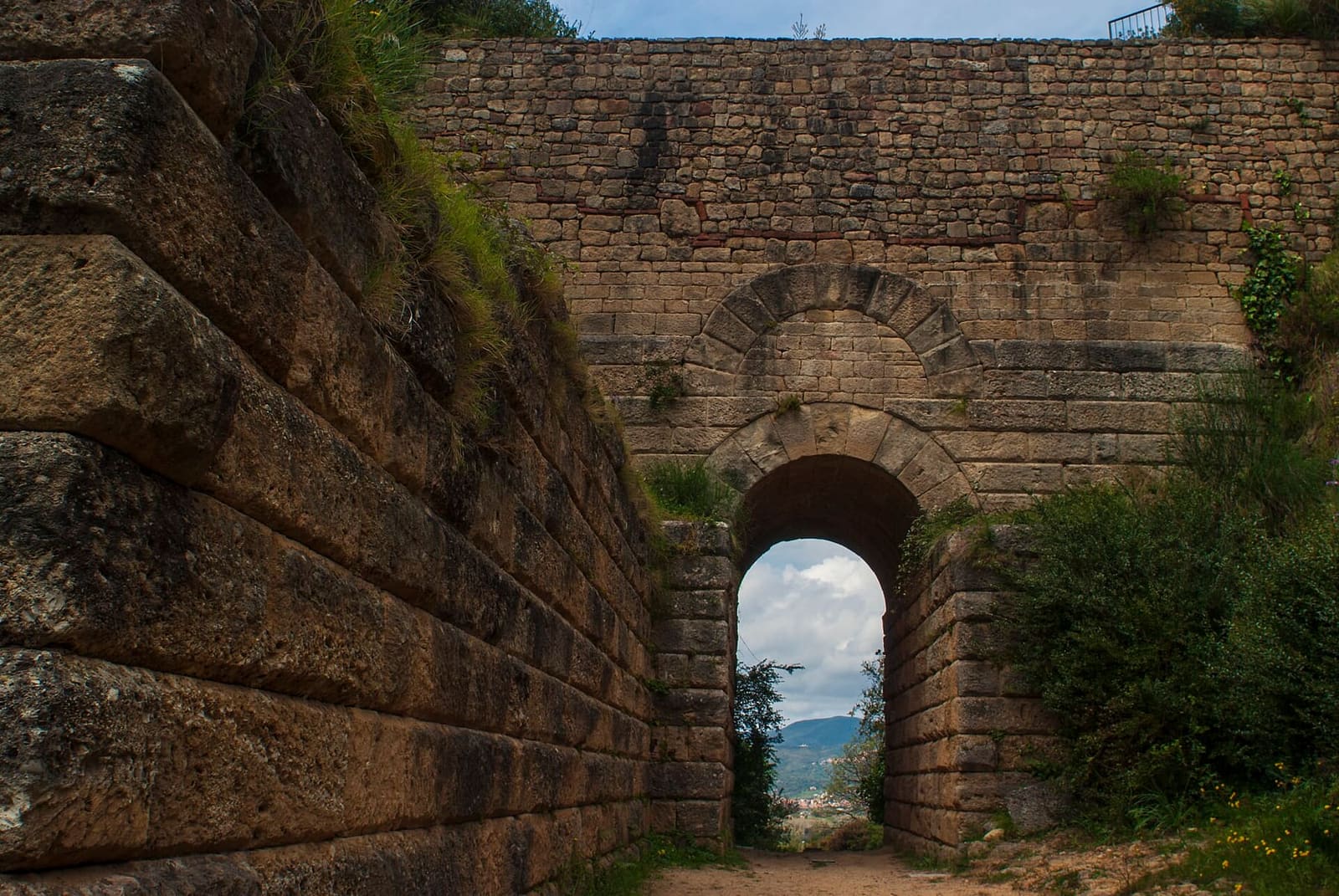 Porta Rosa, l'arco di arenaria in fondo alla gola fra le due alture, con le mura a blocchi ai lati
