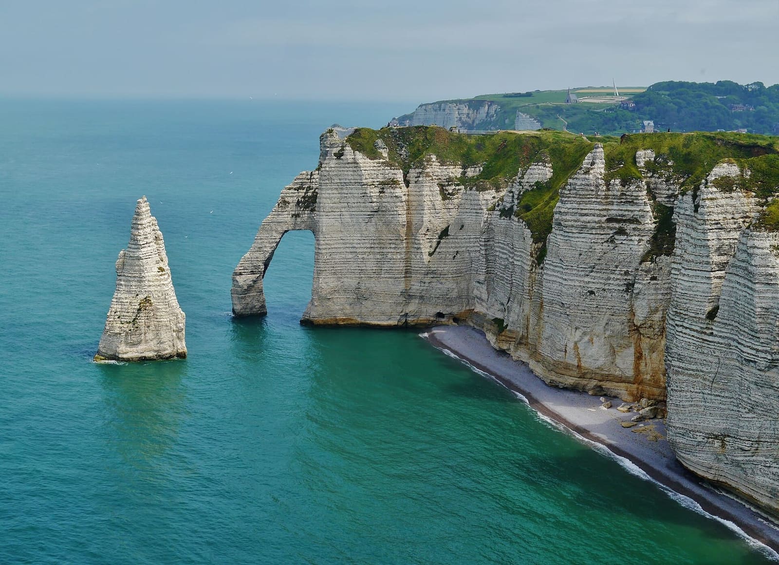 l'Aiguille e la Porte d'Aval viste dall'alto, con la spiaggetta ai piedi della falesia e il mare verde, a giugno