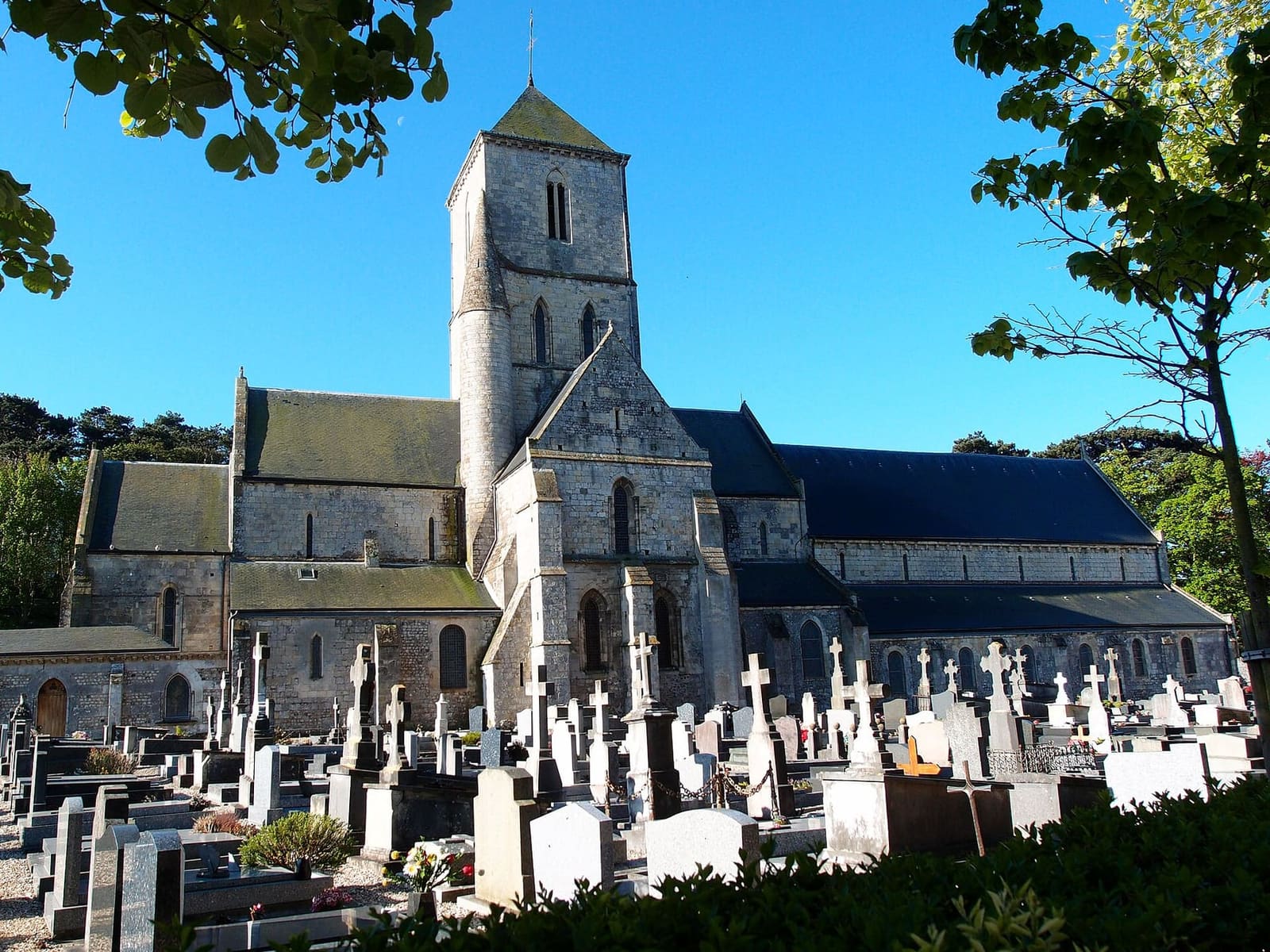 l'église Notre-Dame con la torre sopra la crociera, dietro le tombe del cimitero, a maggio