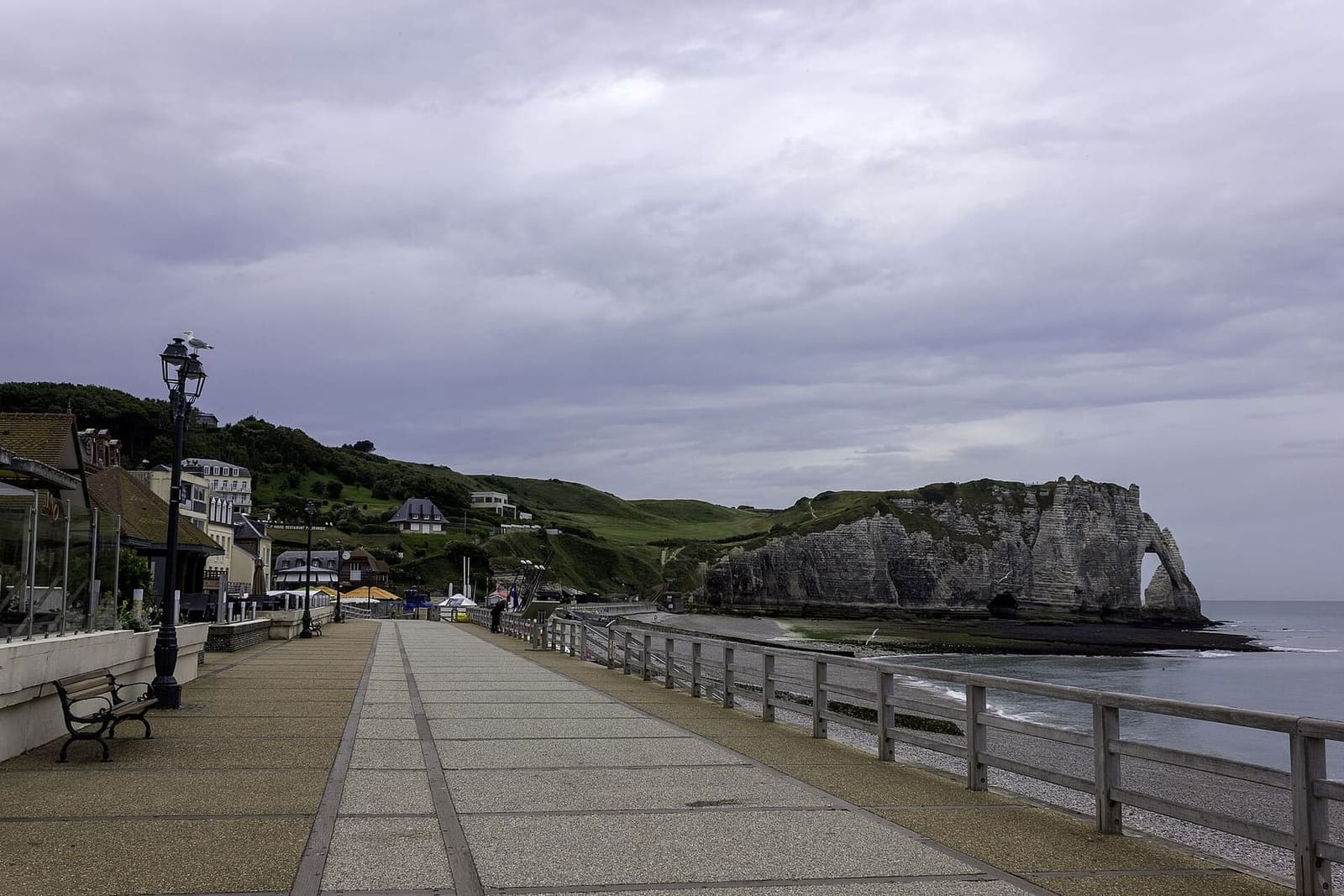 la passeggiata a mare sopra la spiaggia, quasi vuota, con la falaise d'Aval in fondo