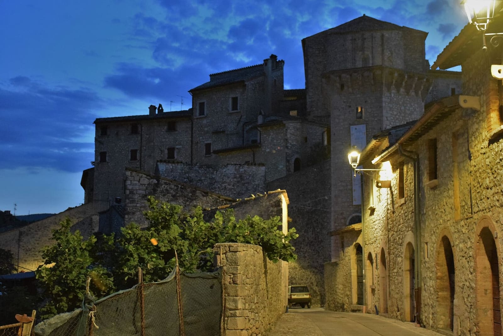 il castello di Vallo di Nera all'ora blu, con le vie del borgo illuminate