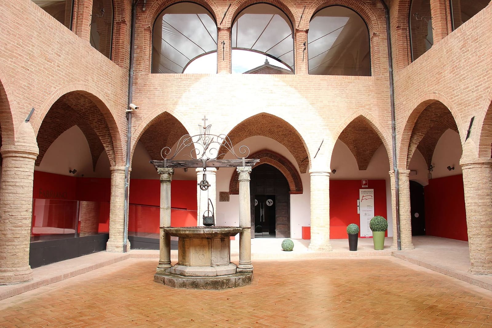 il chiostro dell'ospedale con il pozzo in mezzo e le arcate su due piani