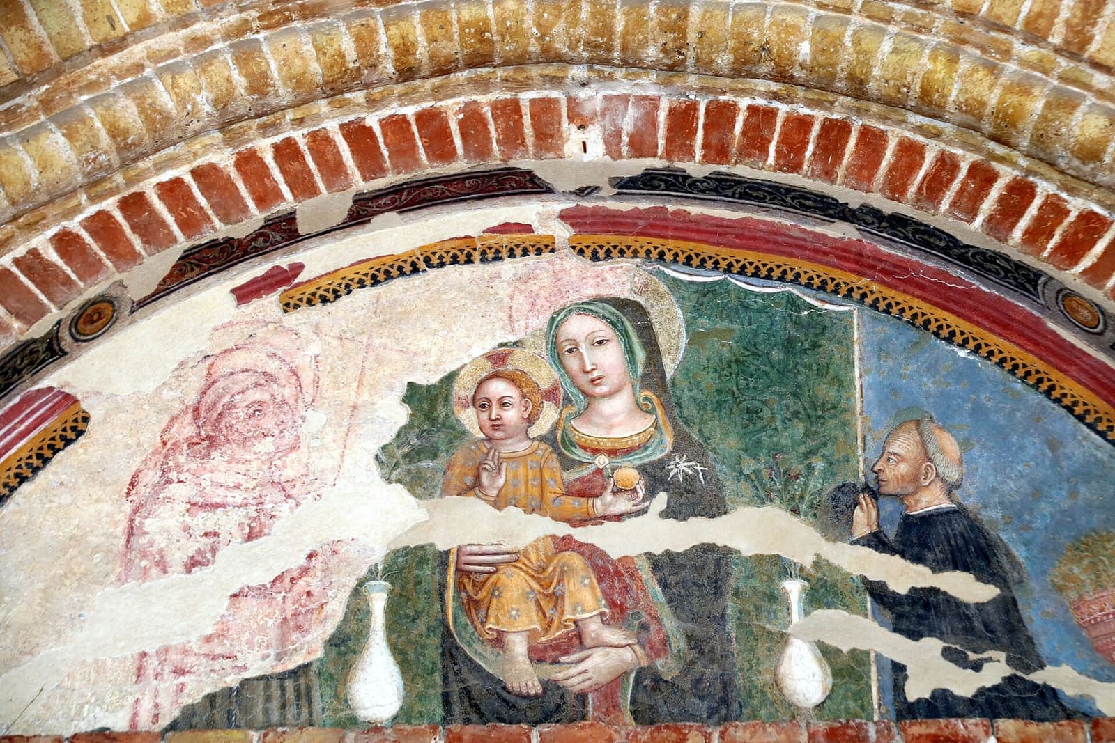 la lunetta affrescata sul portale dell'ospedale, la Madonna con il Bambino, un santo e il donatore, del Maestro di Staffolo