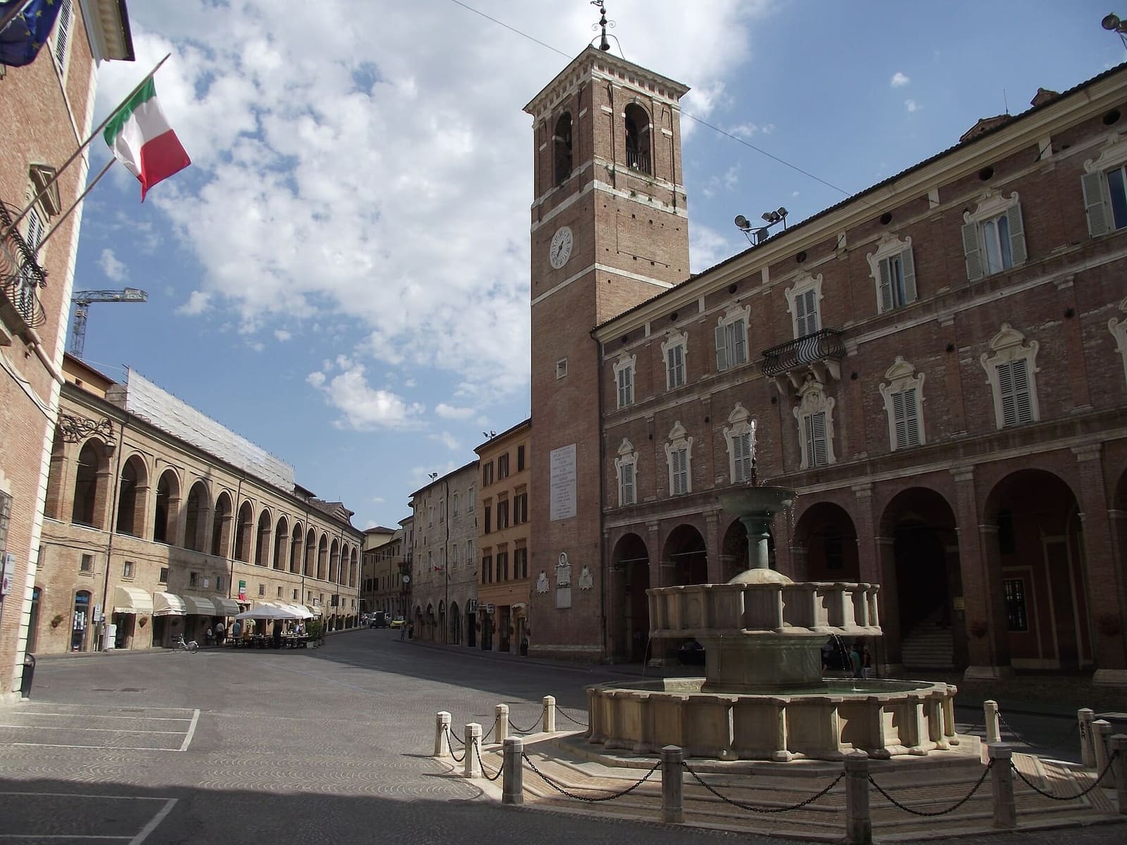 piazza del Comune con la fontana Sturinalto, il palazzo comunale con la torre civica dell'orologio e a sinistra le arcate del loggiato di San Francesco