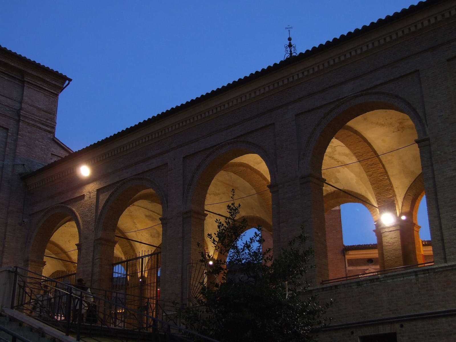 le arcate del loggiato illuminate all'imbrunire