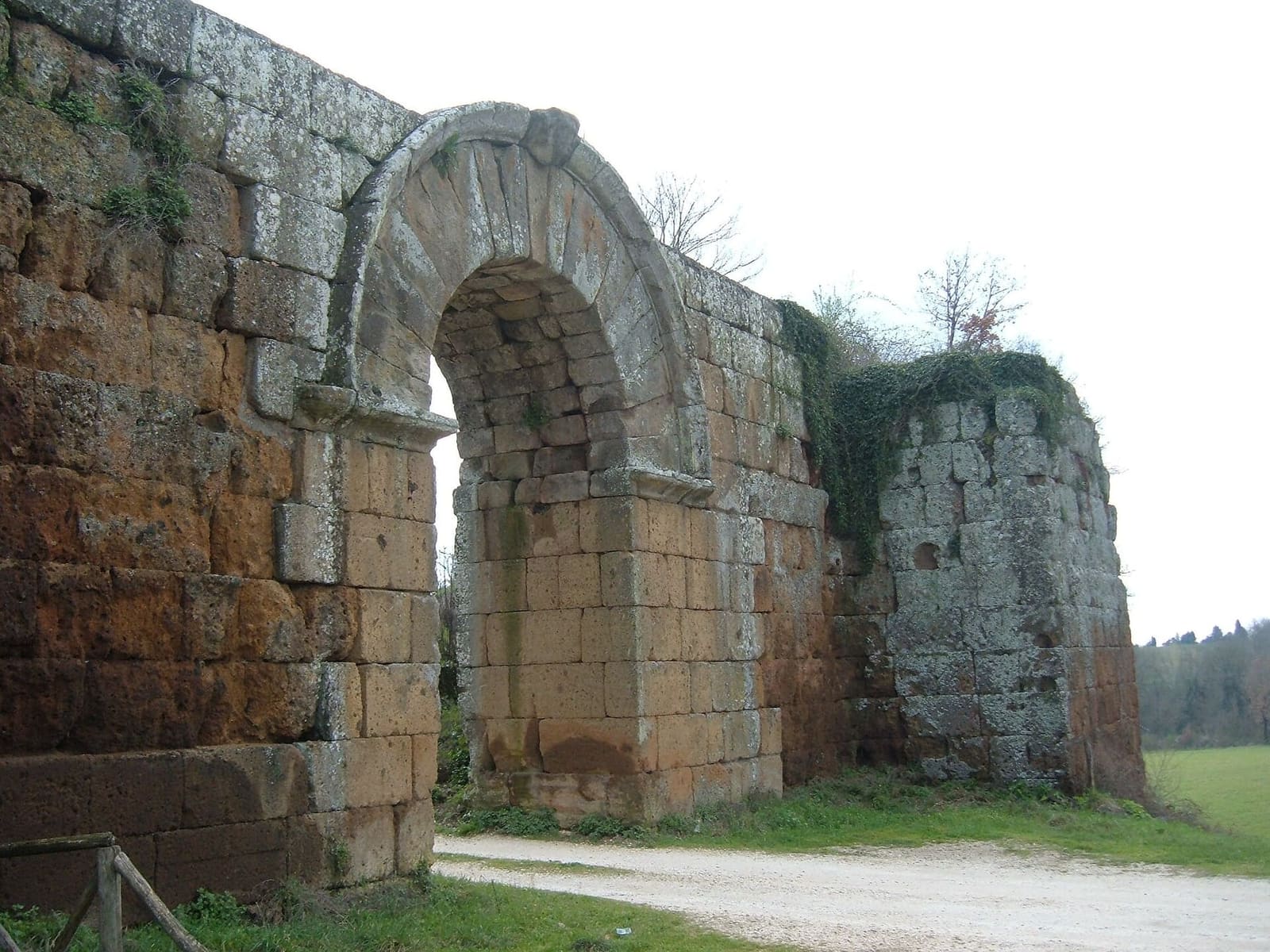 la Porta di Giove dal lato esterno, di scorcio: lo spessore dell'arco, le mensole sui piedritti e i blocchi squadrati della cinta che proseguono a destra