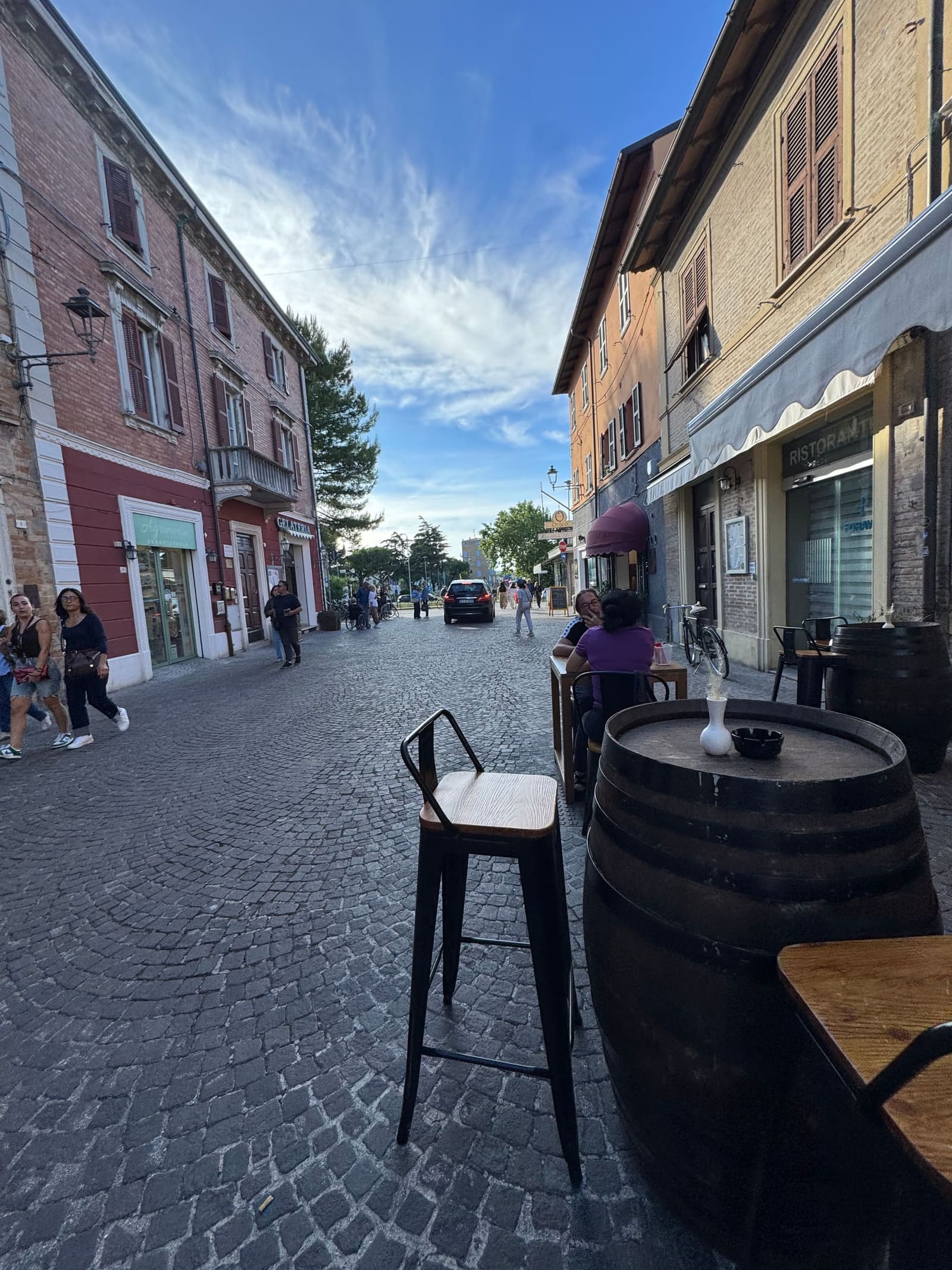 il corso la sera, con la botte usata come tavolo davanti a un locale