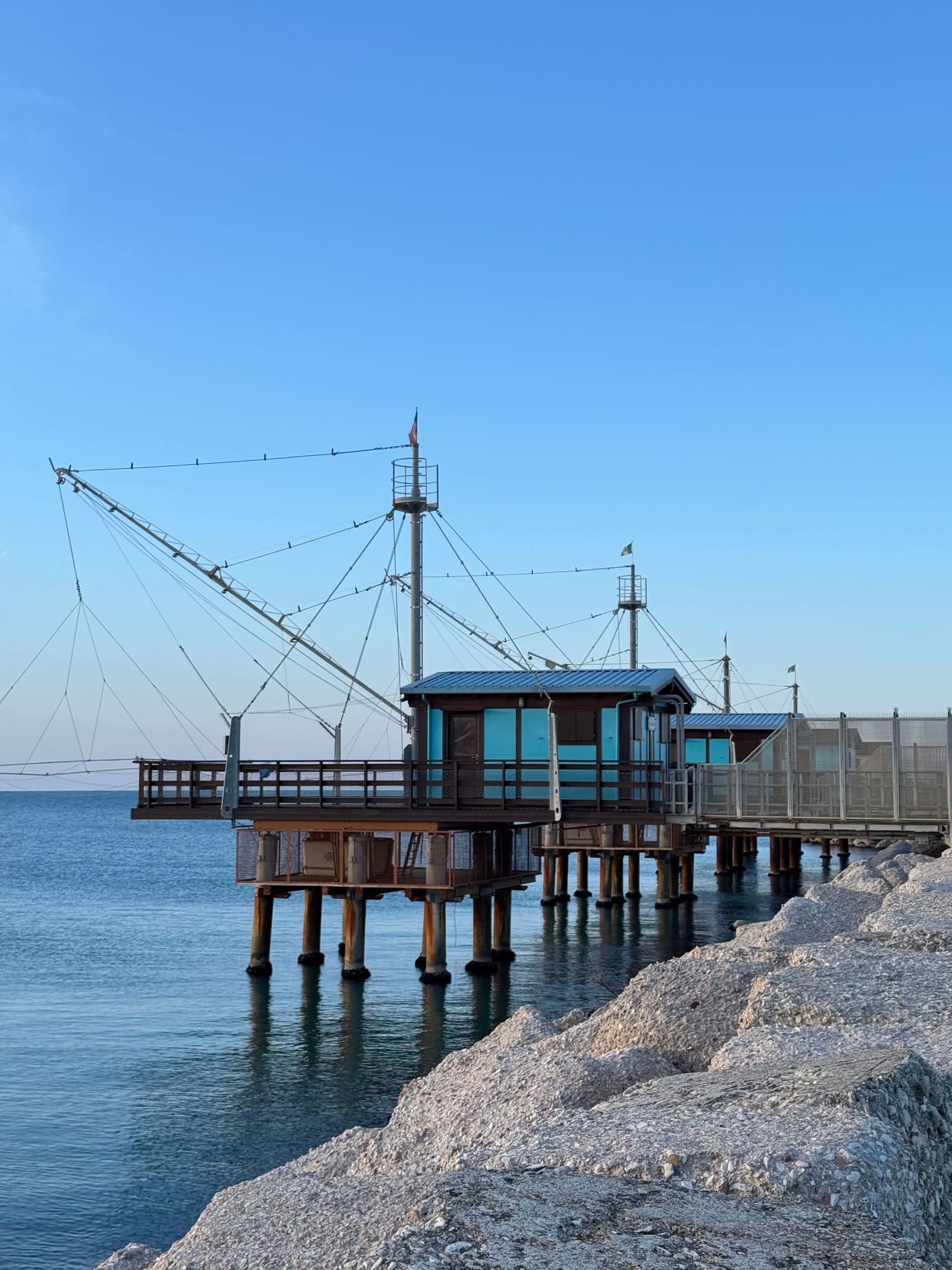 il trabucco sui pali e la scogliera davanti, con il mare fermo