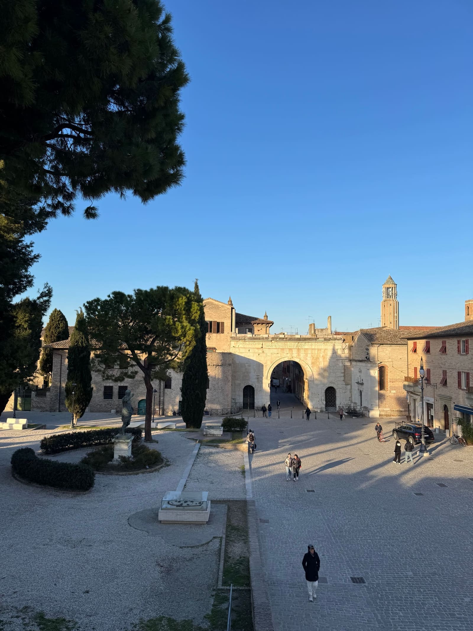 la piazza aperta con l'Arco d'Augusto in fondo
