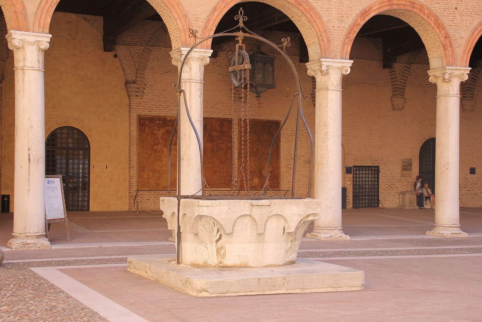 der Brunnen und der Säulengang im Hof des Castello Estense
