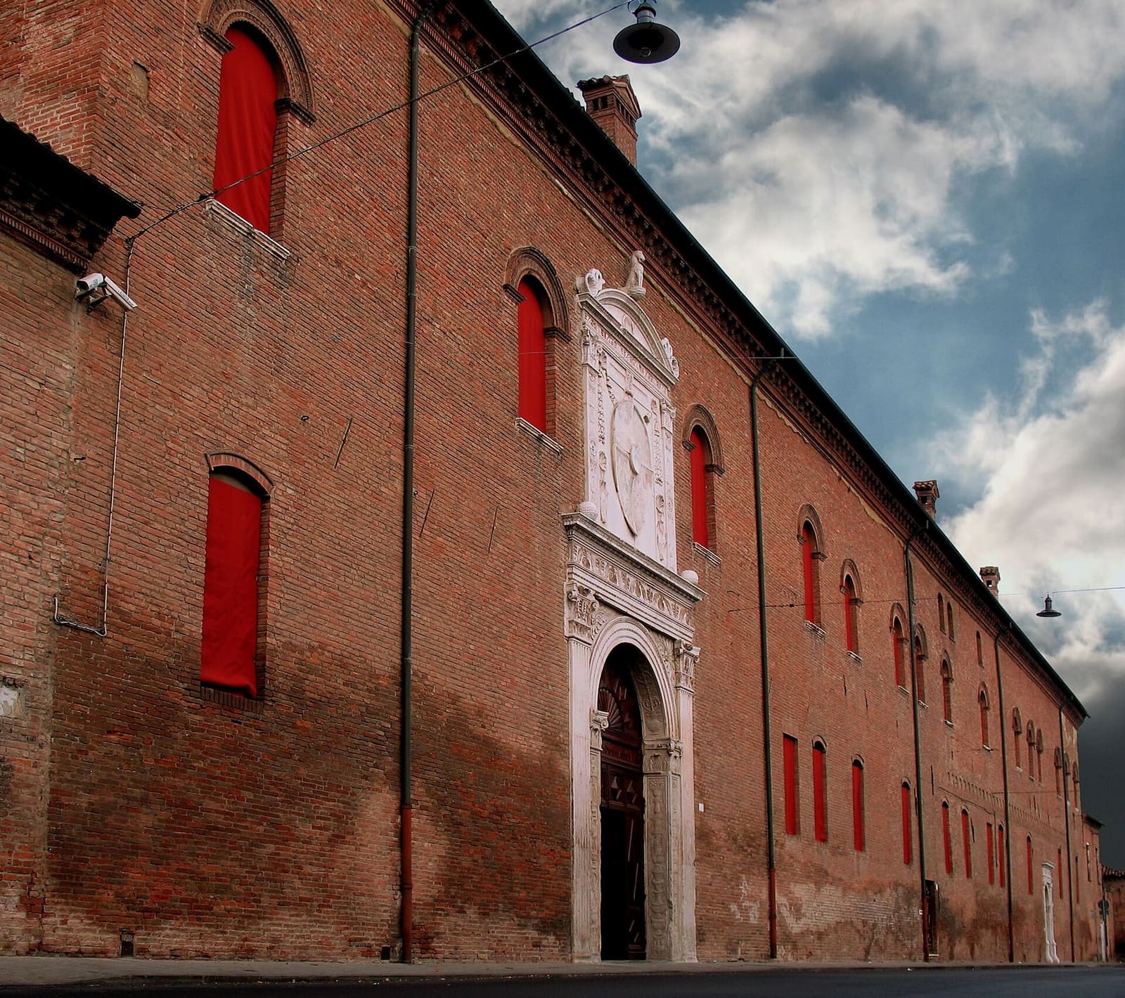 die lange Ziegelfassade des Palazzo Schifanoia, mit dem Marmorportal, durch das man ins Museum geht