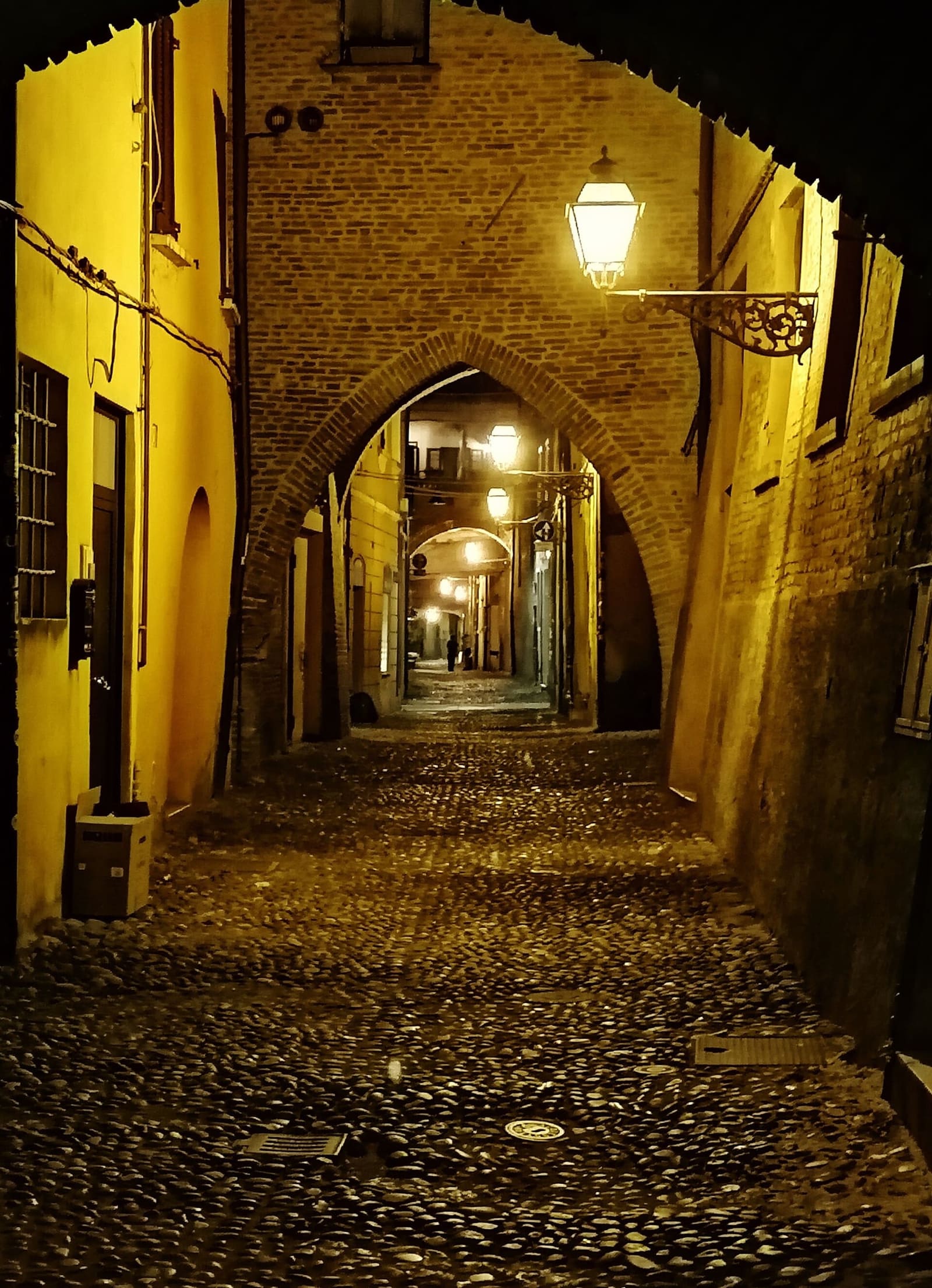 die via delle Volte am Abend, mit den eingeschalteten Laternen unter den Bögen