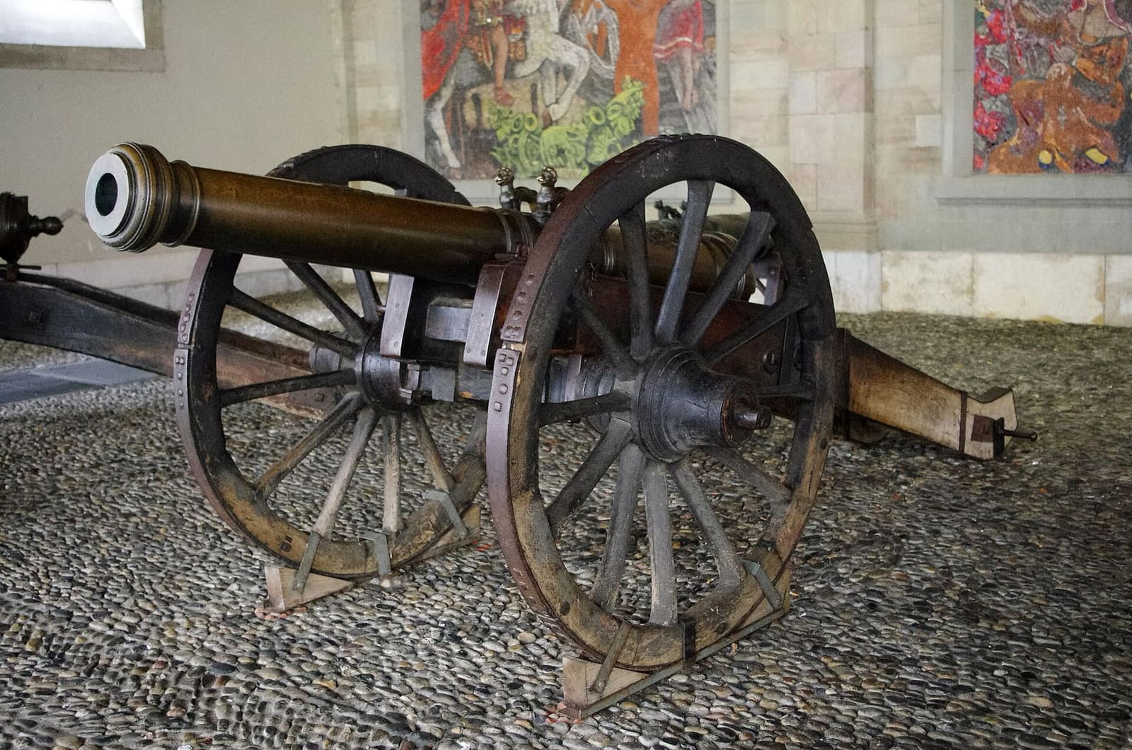 un cannone sotto i portici dell'Ancien Arsenal, davanti ai mosaici di Cingria