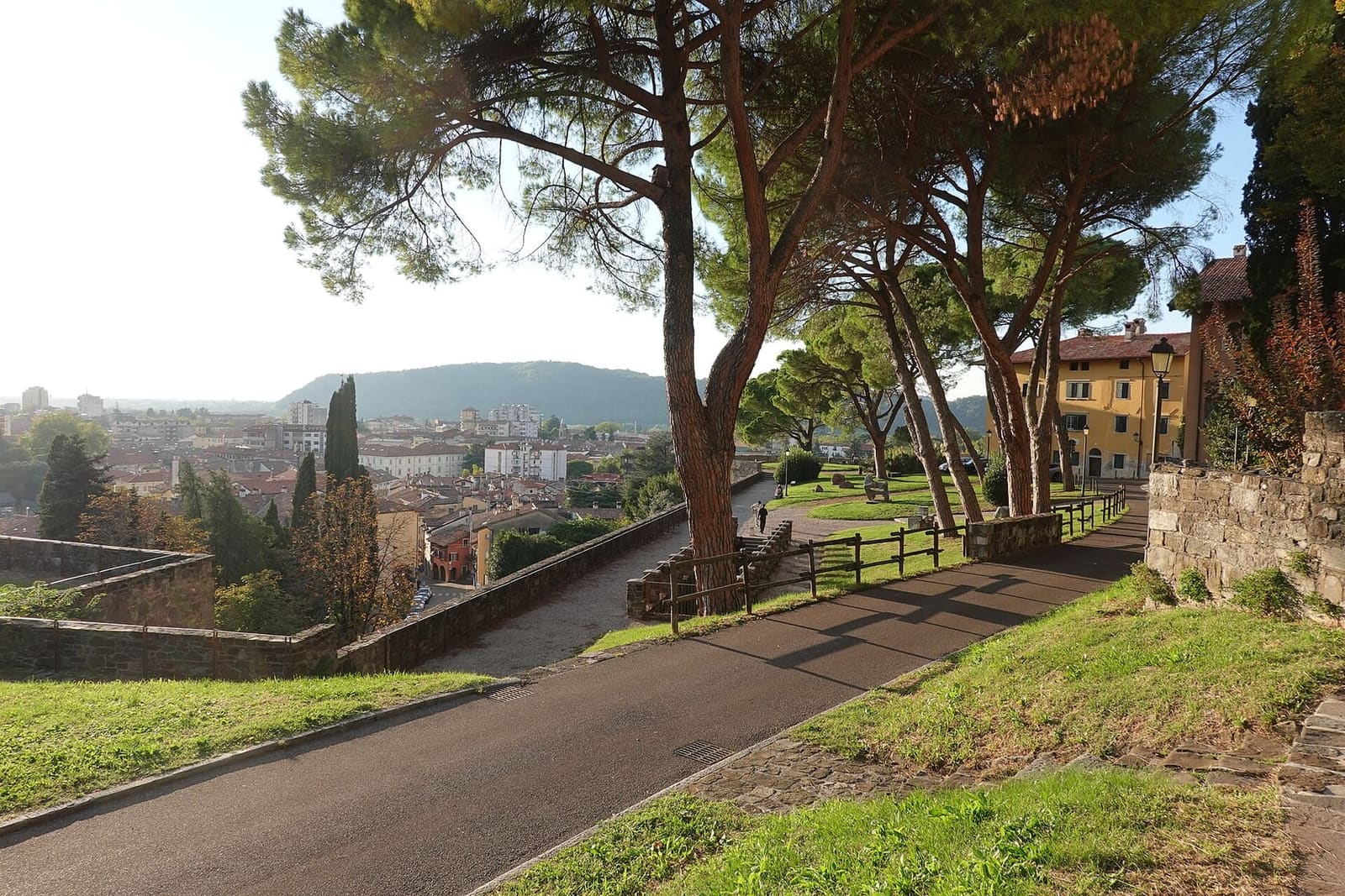 der Weg zwischen den Pinien unter den Mauern des Borgo Castello, mit der Stadt unten