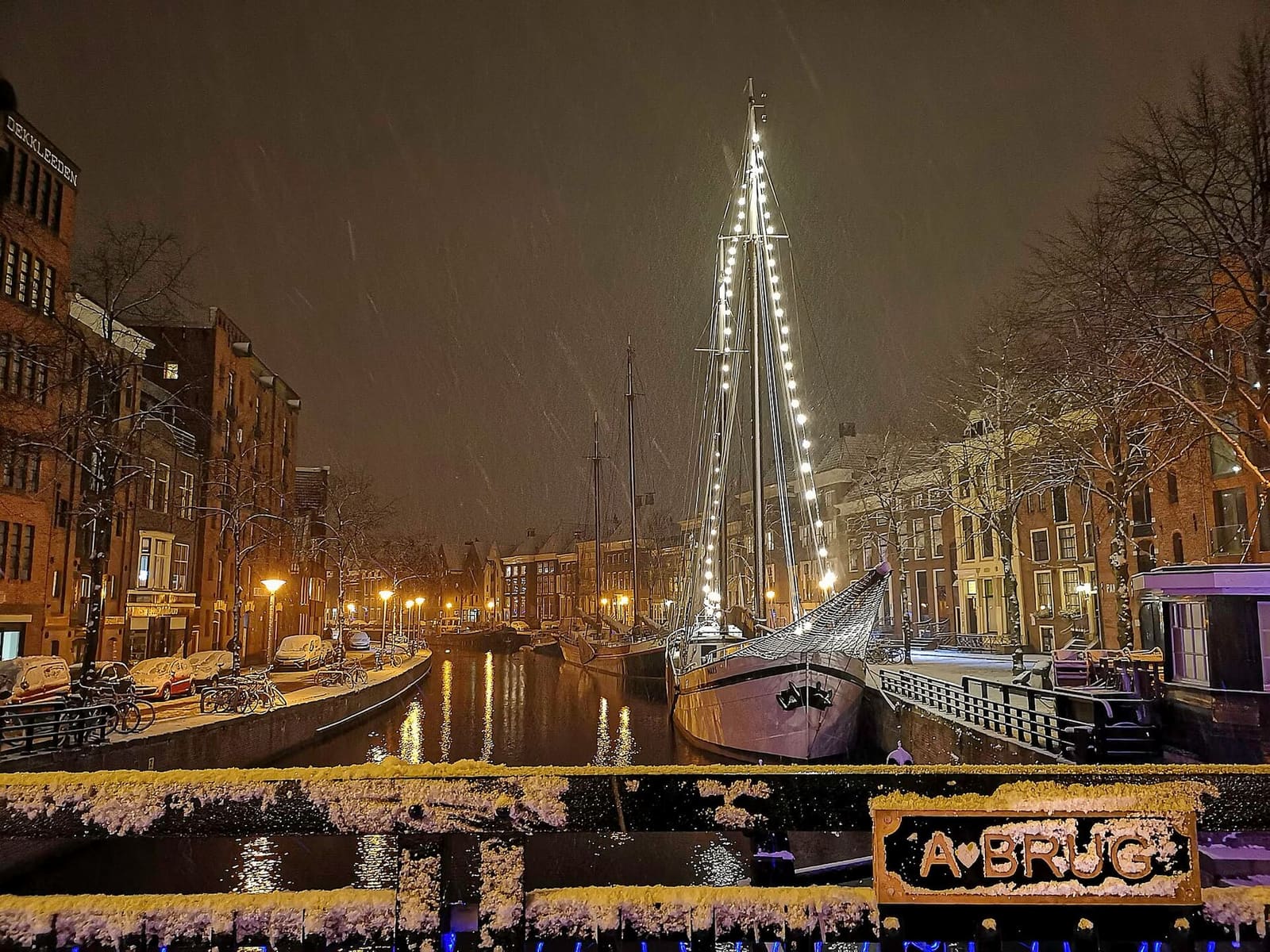 la Hoge e la Lage der A sotto la neve, viste di notte dall'Abrug, con un veliero illuminato