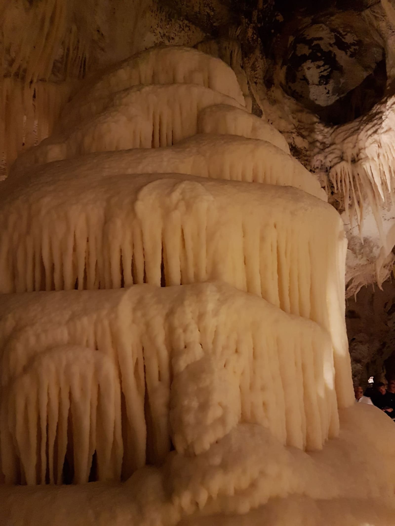 una colata di calcite a pieghe sovrapposte, con la frangia di stalattiti corte sotto ogni piega