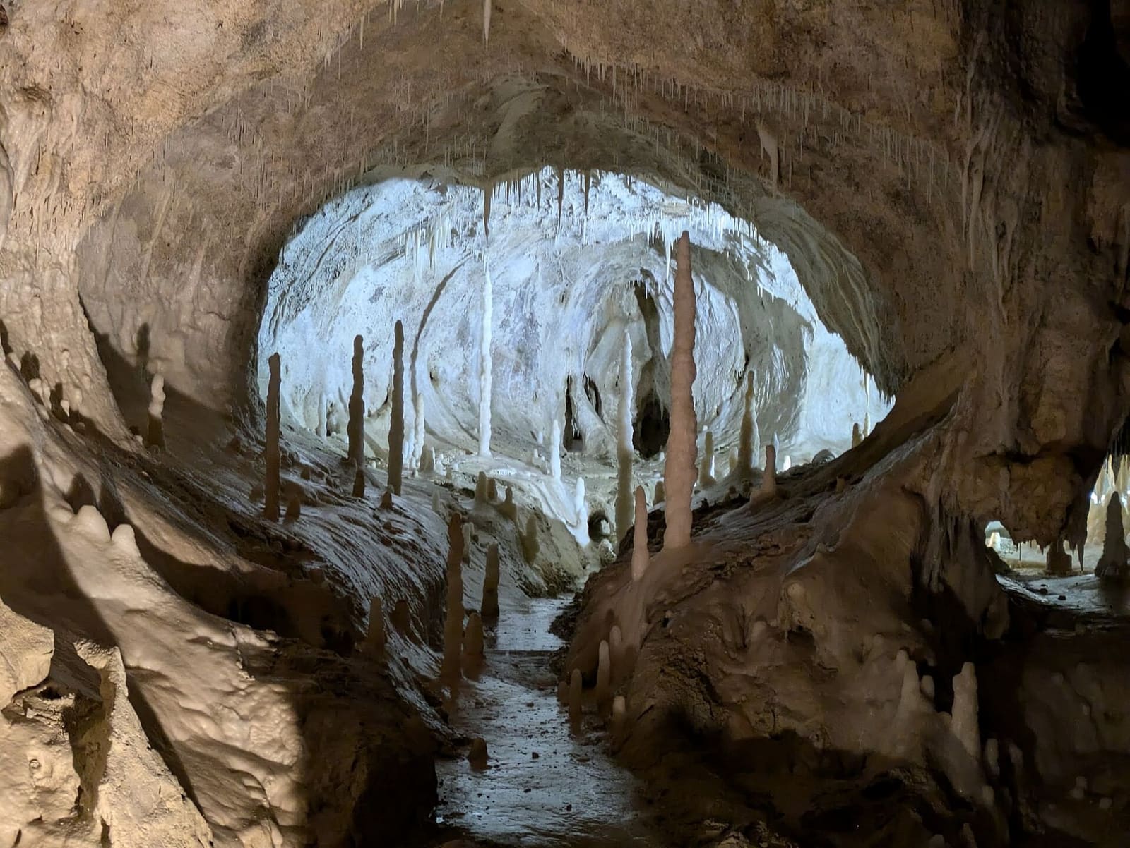 un'apertura nella roccia scura, e di là una sala bianca con le colonne illuminate