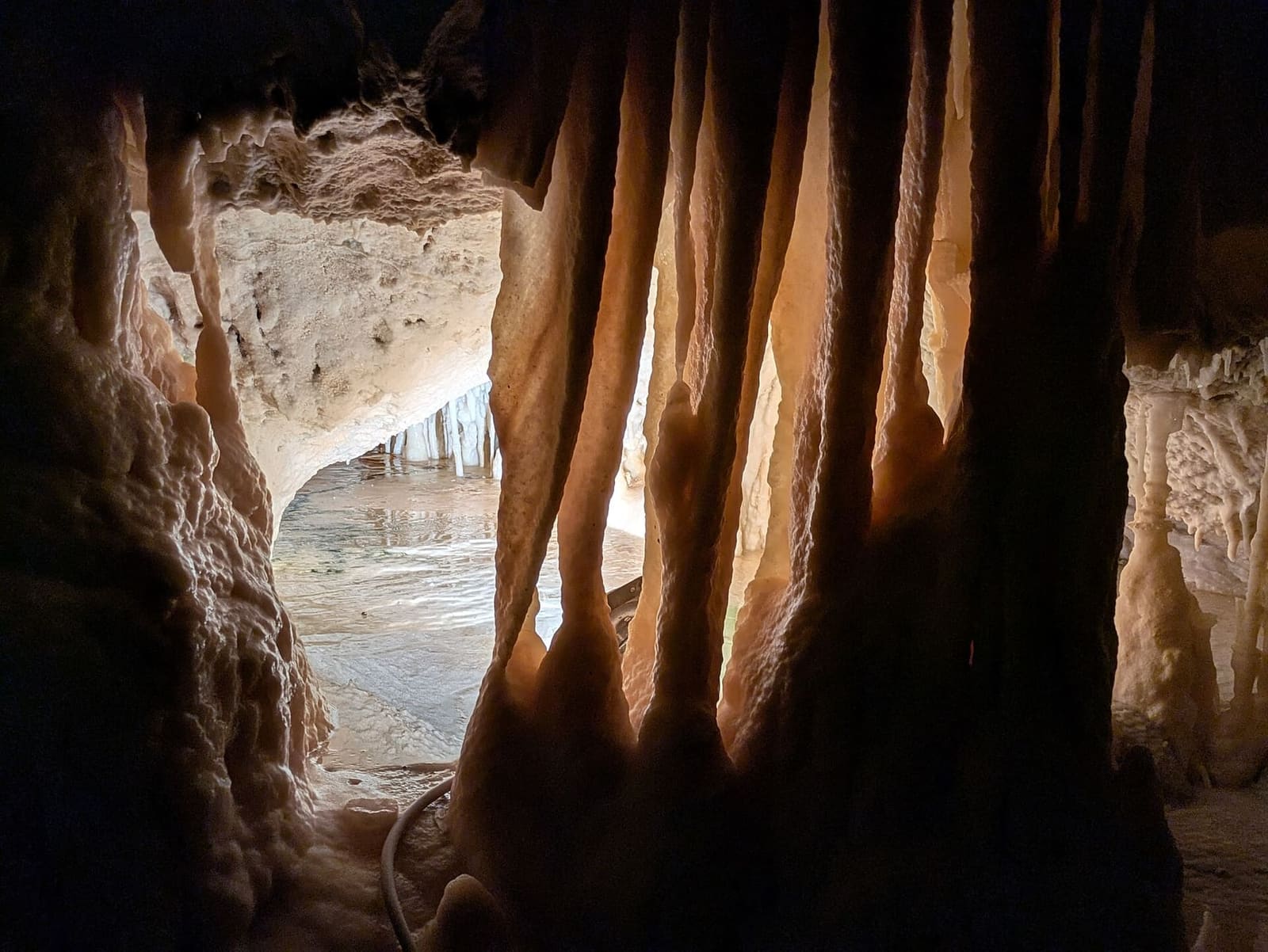 le concrezioni a canne d'organo in controluce, e dietro la sala illuminata