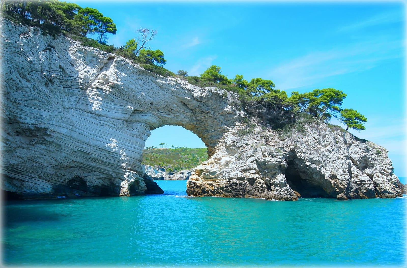 l'Architiello visto dal mare, con l'acqua turchese sotto l'arco