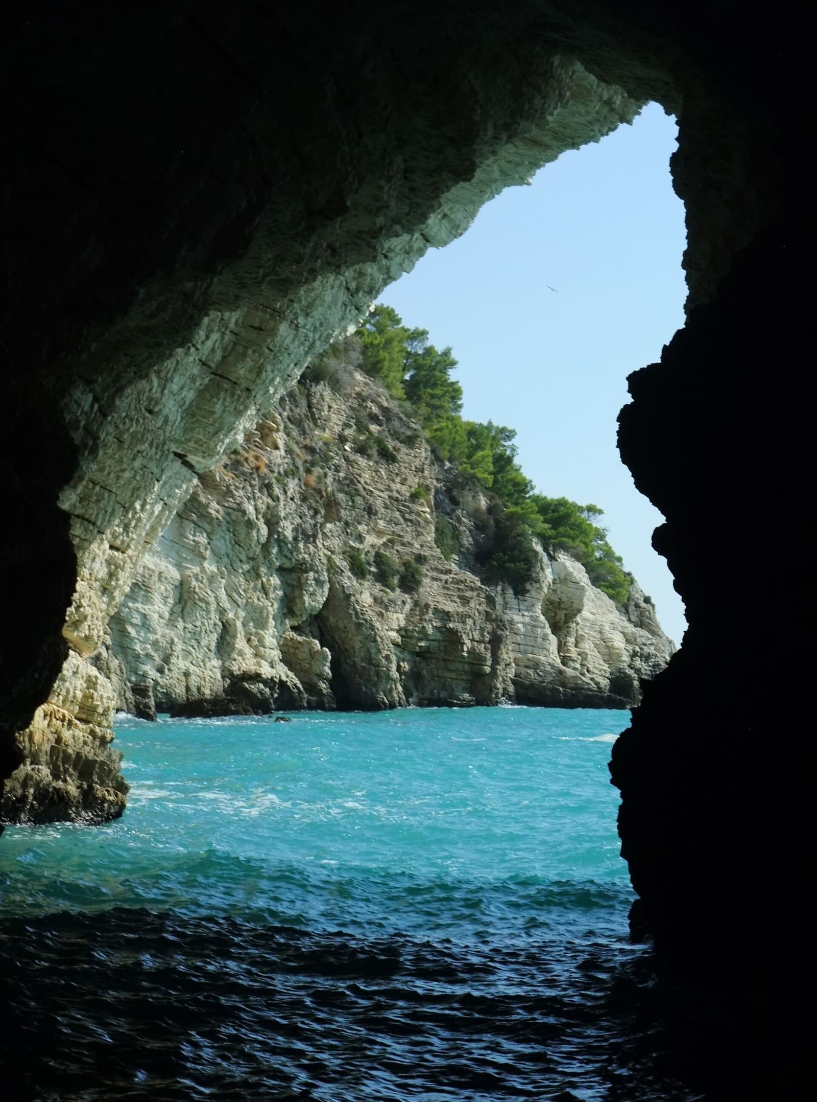 l'uscita di una grotta, con la costa e il mare fuori