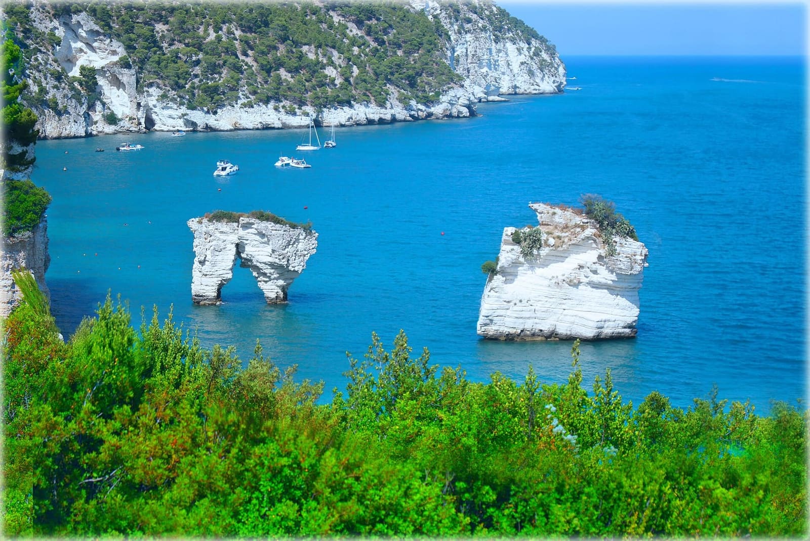 la Baia delle Zagare dall'alto, con le barche ferme davanti alla scogliera