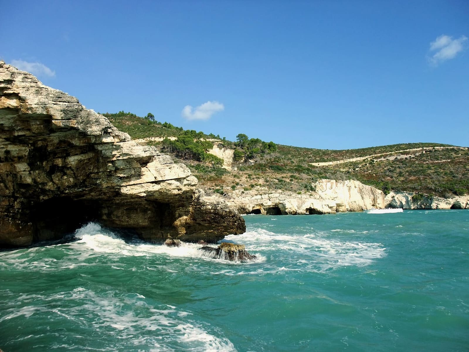 la costa a sud di Vieste vista dalla barca, con le onde sulla scogliera