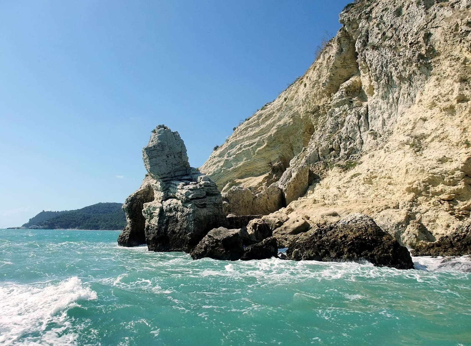 un faraglione staccato dalla scogliera, lungo la costa