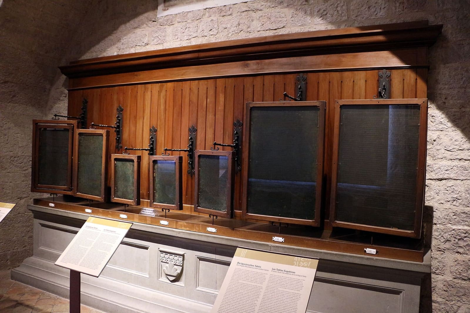 le sette Tavole Eugubine nella loro sala del museo civico, ciascuna nella sua cornice di legno