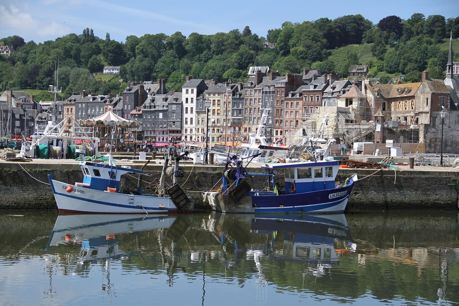 i pescherecci ormeggiati nell'avant-port, con le case del Vieux Bassin riflesse nell'acqua, a giugno