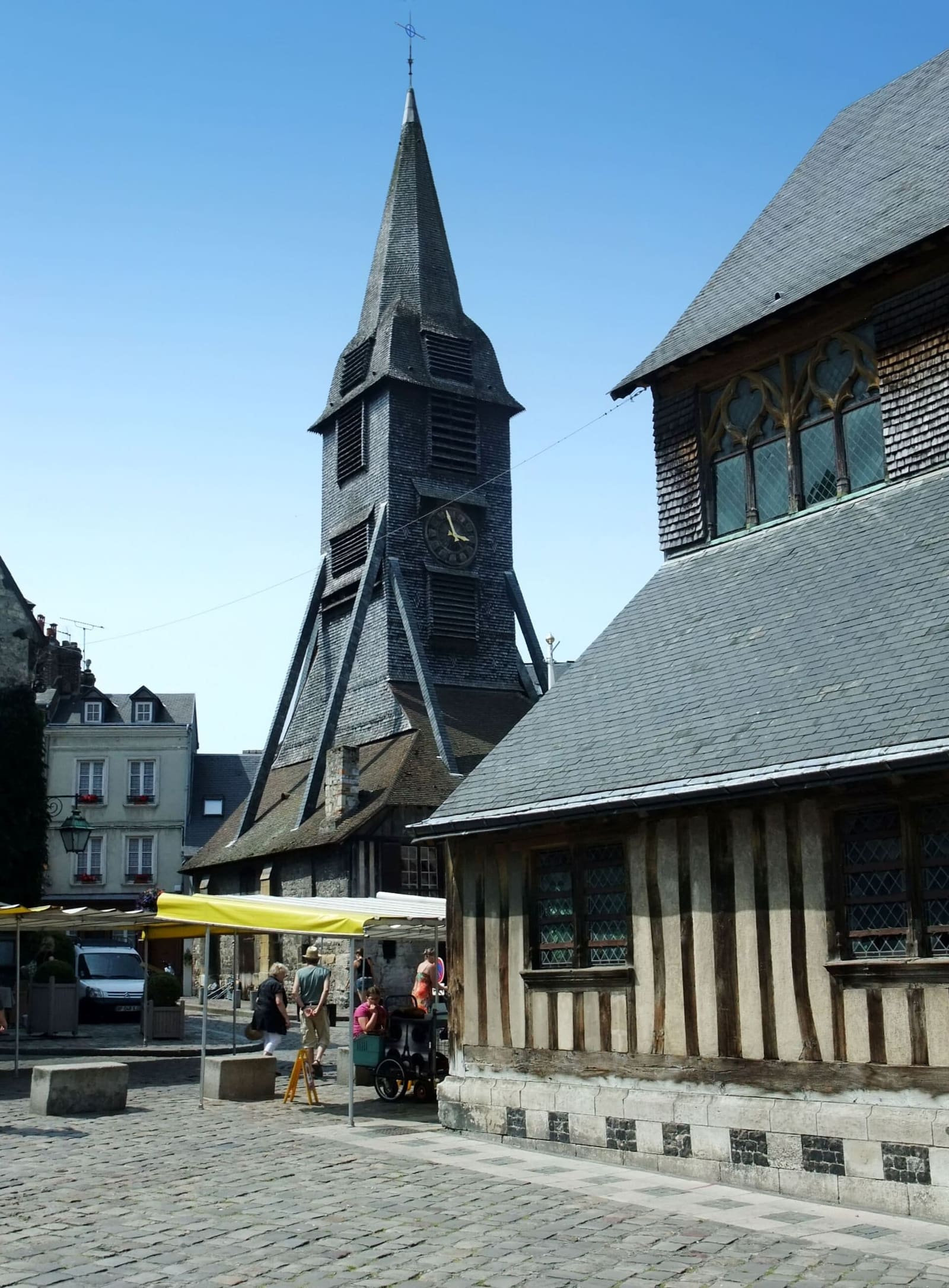 il clocher Sainte-Catherine, il campanile di legno staccato dalla chiesa, con le bancarelle del mercato sotto, a luglio