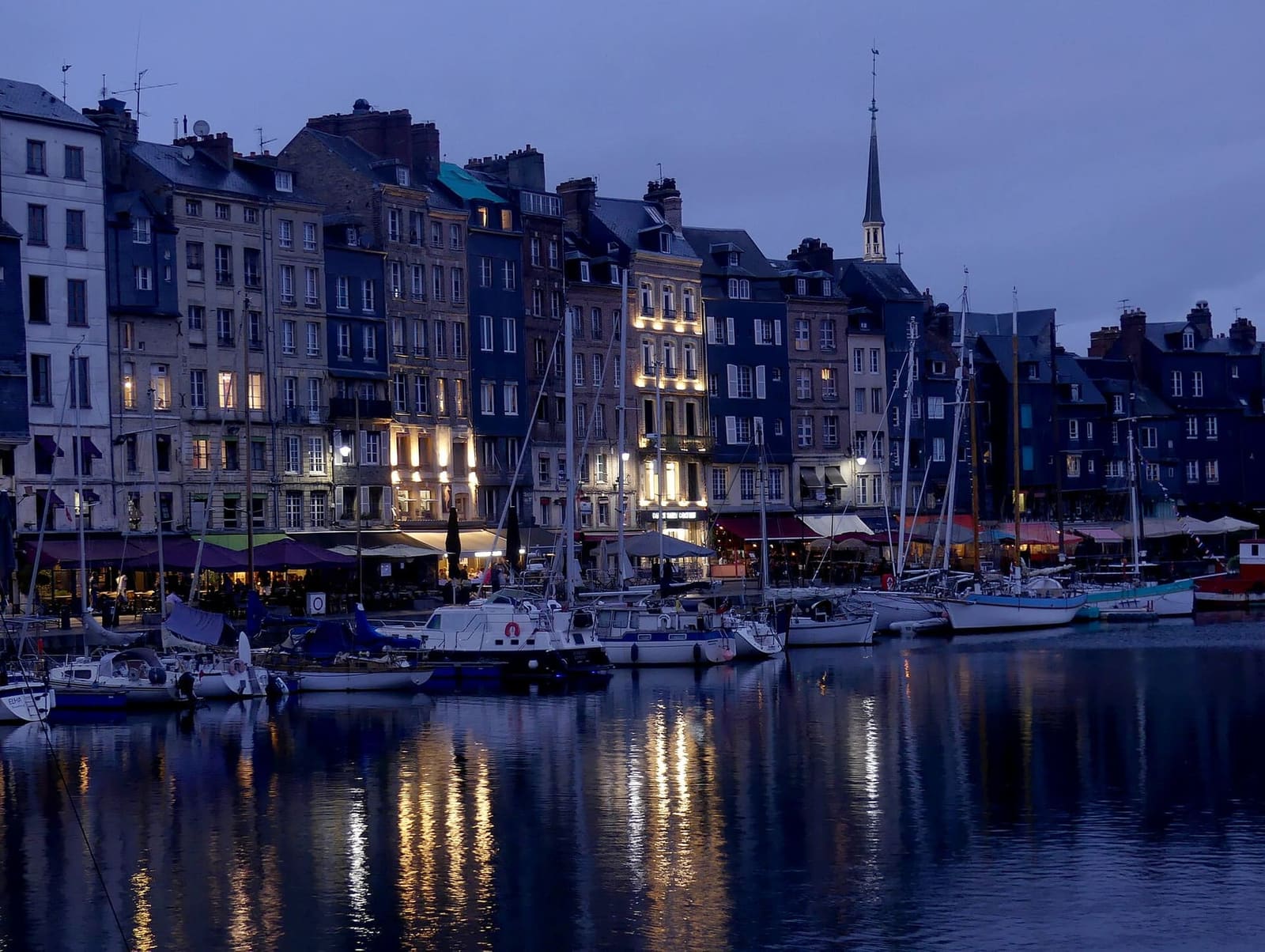 il quai Sainte-Catherine al crepuscolo, con le finestre accese e le barche nel Vieux Bassin, a luglio