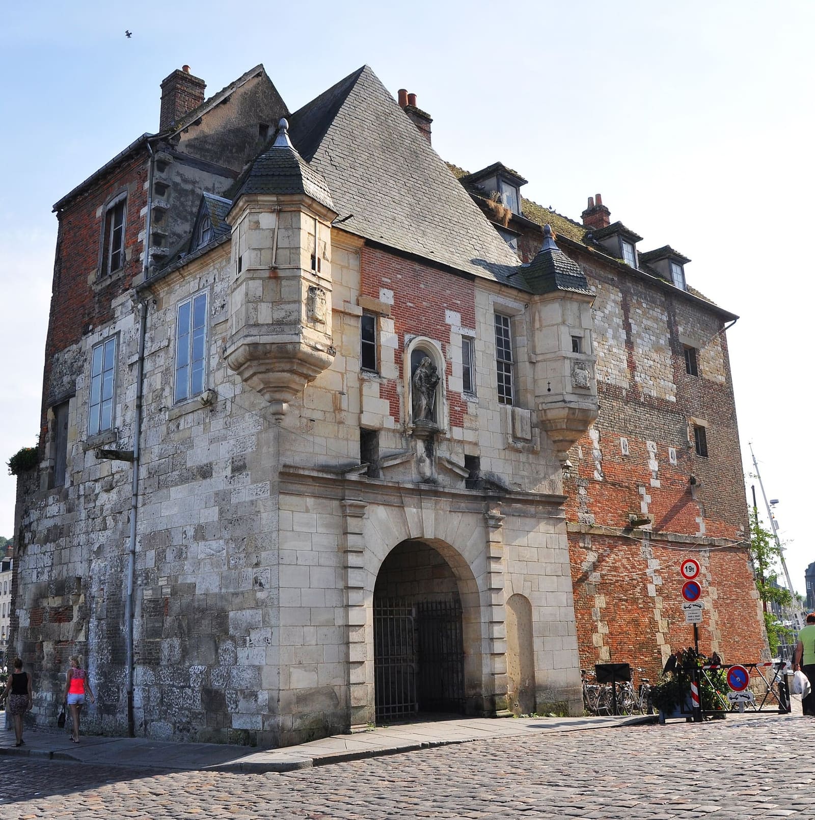 la porta ad arco della Lieutenance, con le due torrette pensili e la Madonna nella nicchia, a settembre