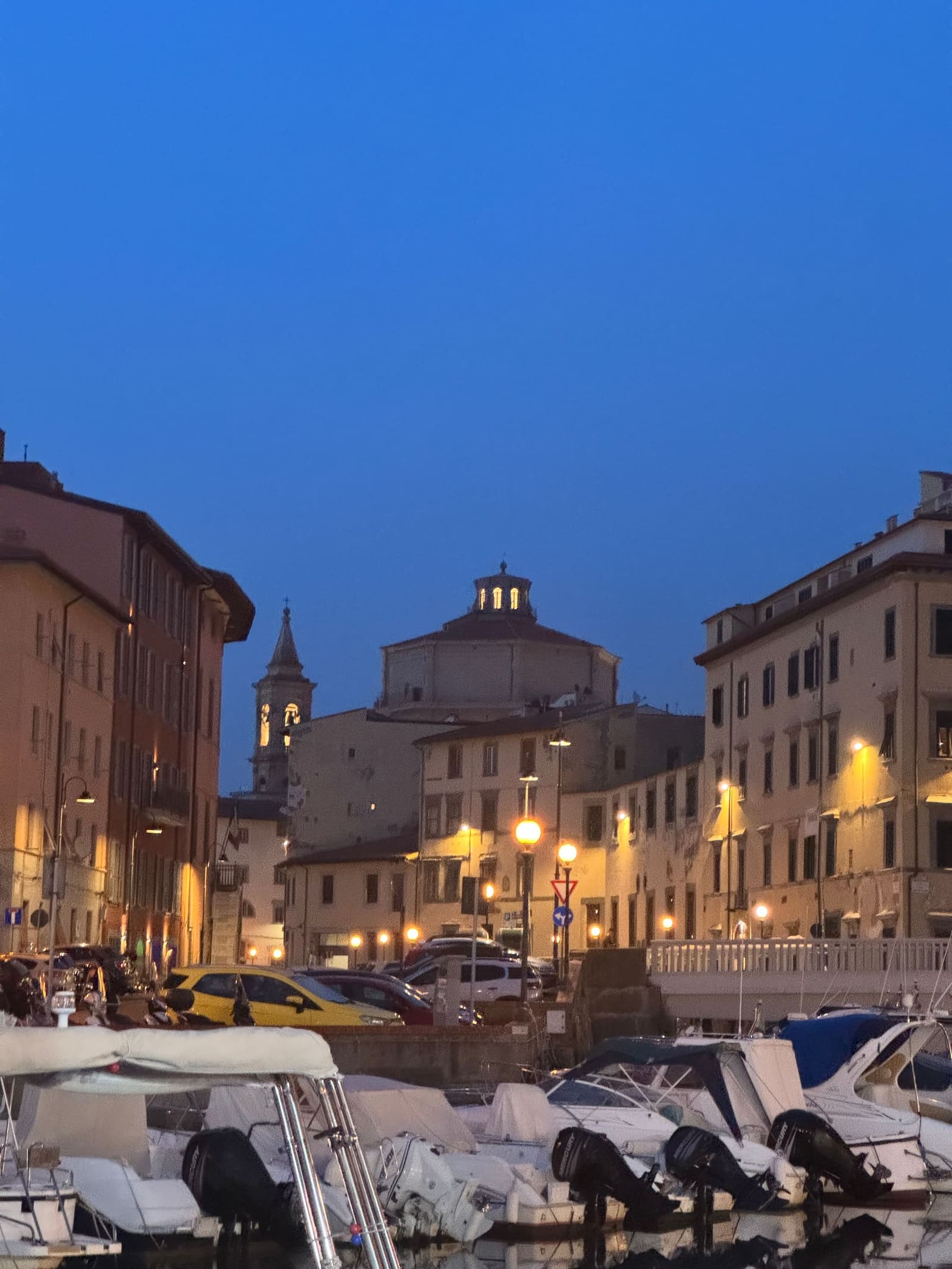 la cupola e il campanile di Santa Caterina all'imbrunire, sopra le barche ormeggiate