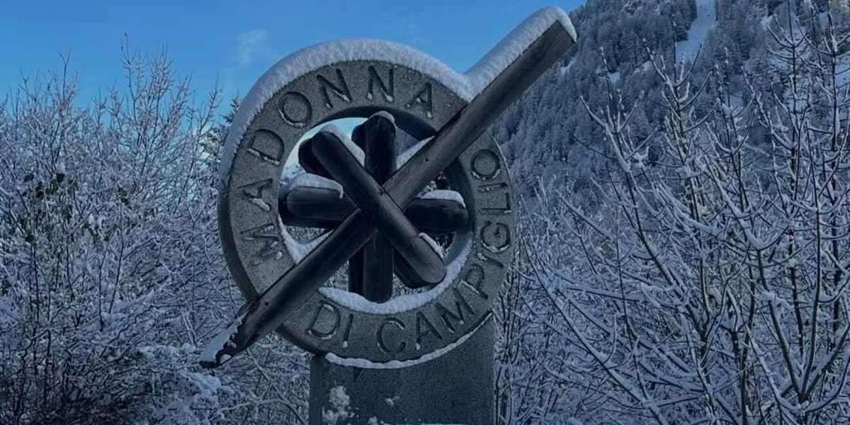 l'insegna di pietra di Madonna di Campiglio coperta di neve, fra gli alberi ghiacciati