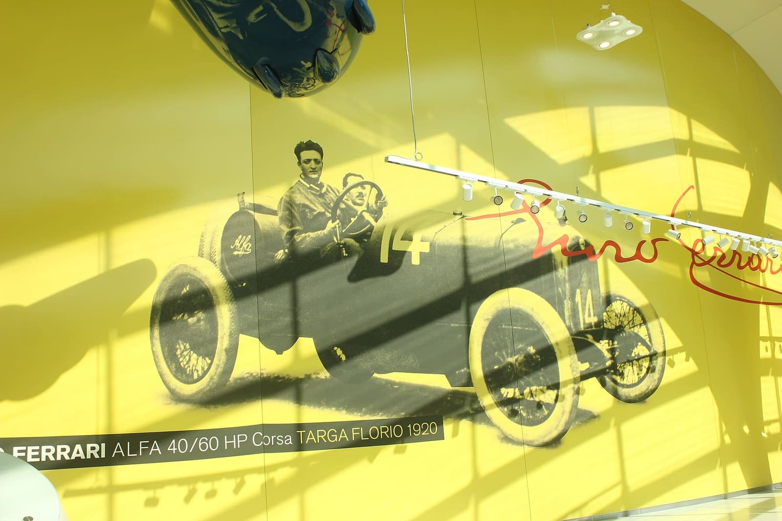 Enzo Ferrari al volante alla Targa Florio del 1920, nella fotografia sulla parete gialla del museo, nel 2019