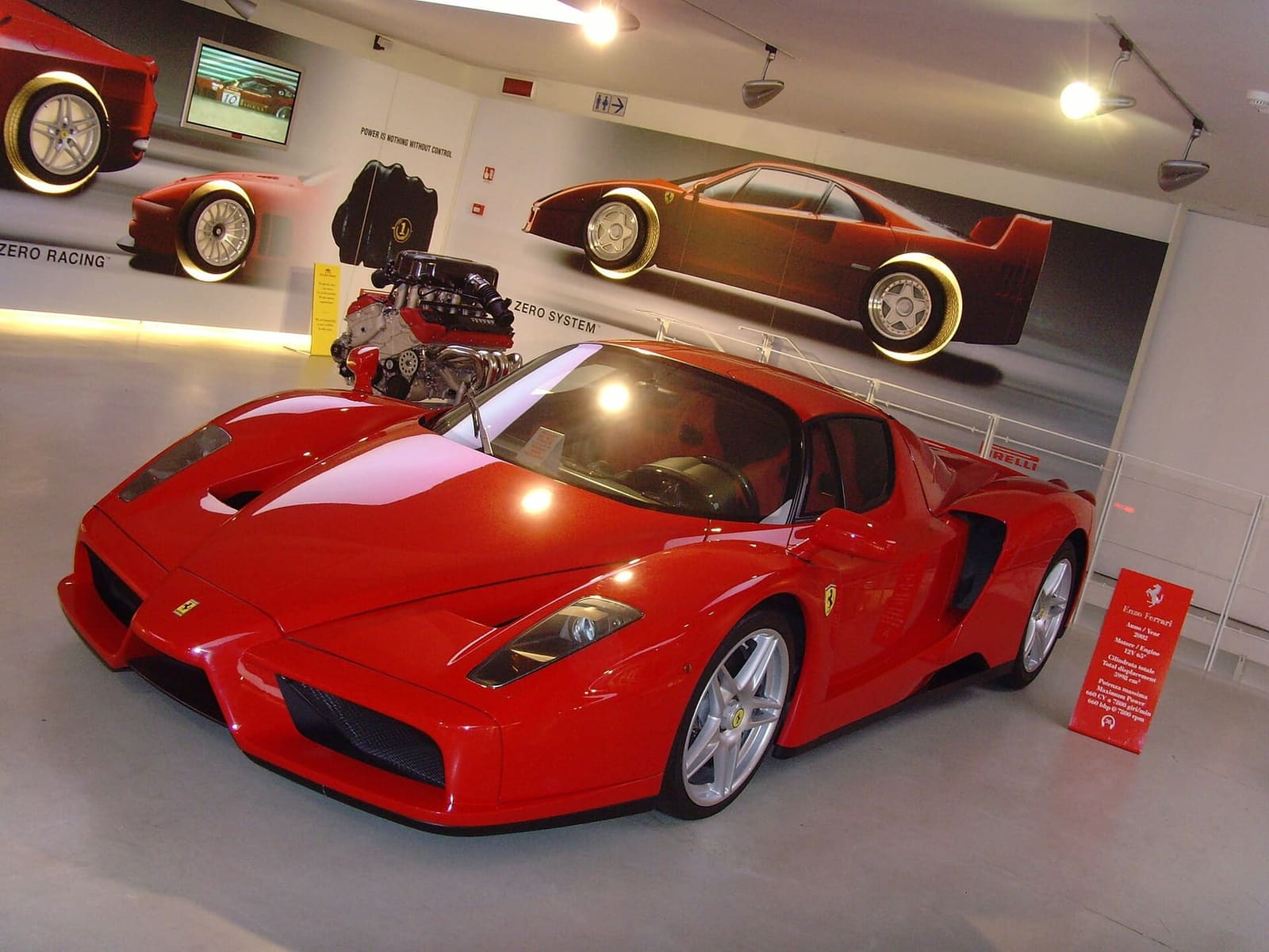 una stradale rossa davanti al suo motore, nel Museo Ferrari di Maranello nel 2008