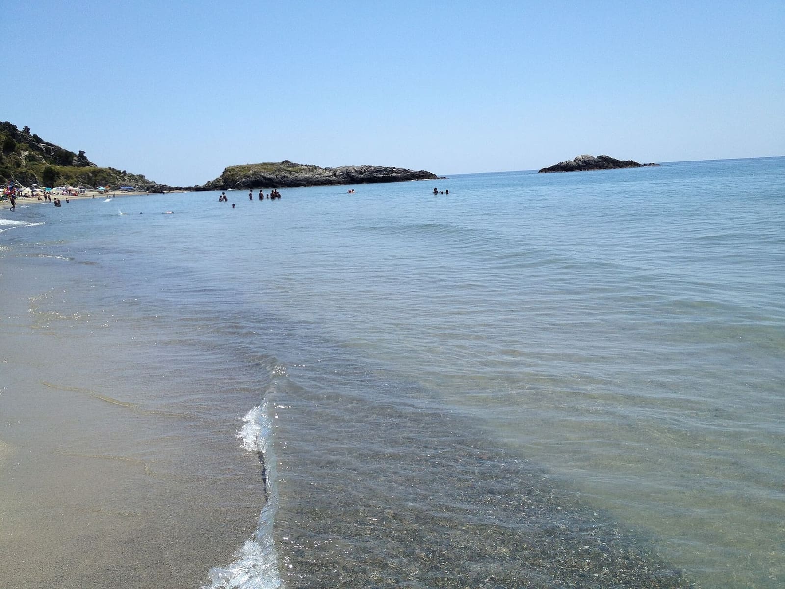 la spiaggia con l'acqua bassa e gli scogli al largo, d'estate