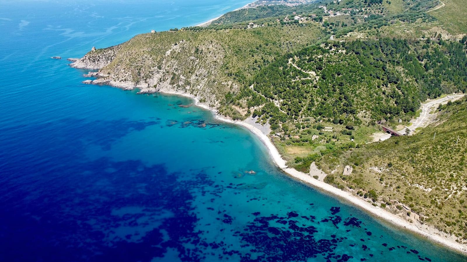 la Punta del Telegrafo vista dall'alto, con la spiaggia e la costa che continua