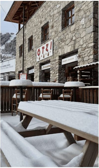 il negozio di articoli sportivi in pietra e legno, con i tavoli all'aperto sotto la neve