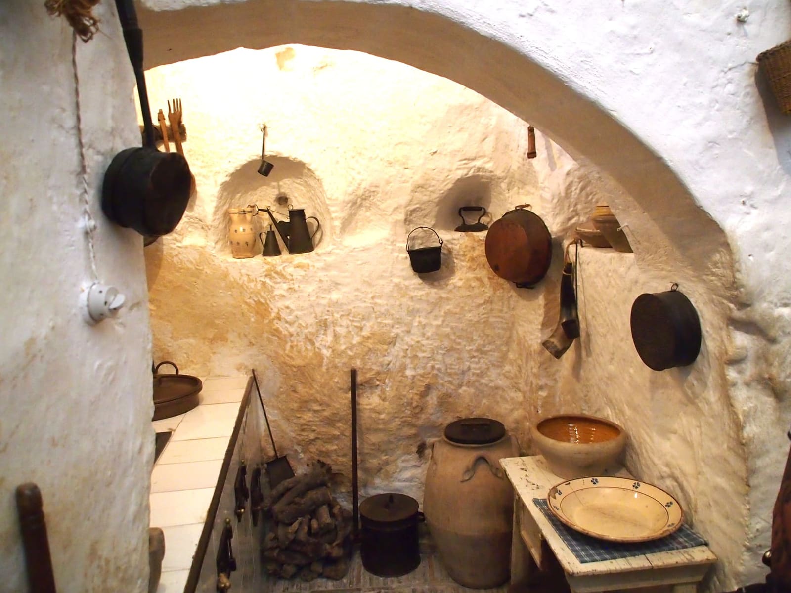 la cucina della Casa Grotta di Vico Solitario, con le pentole appese alla roccia