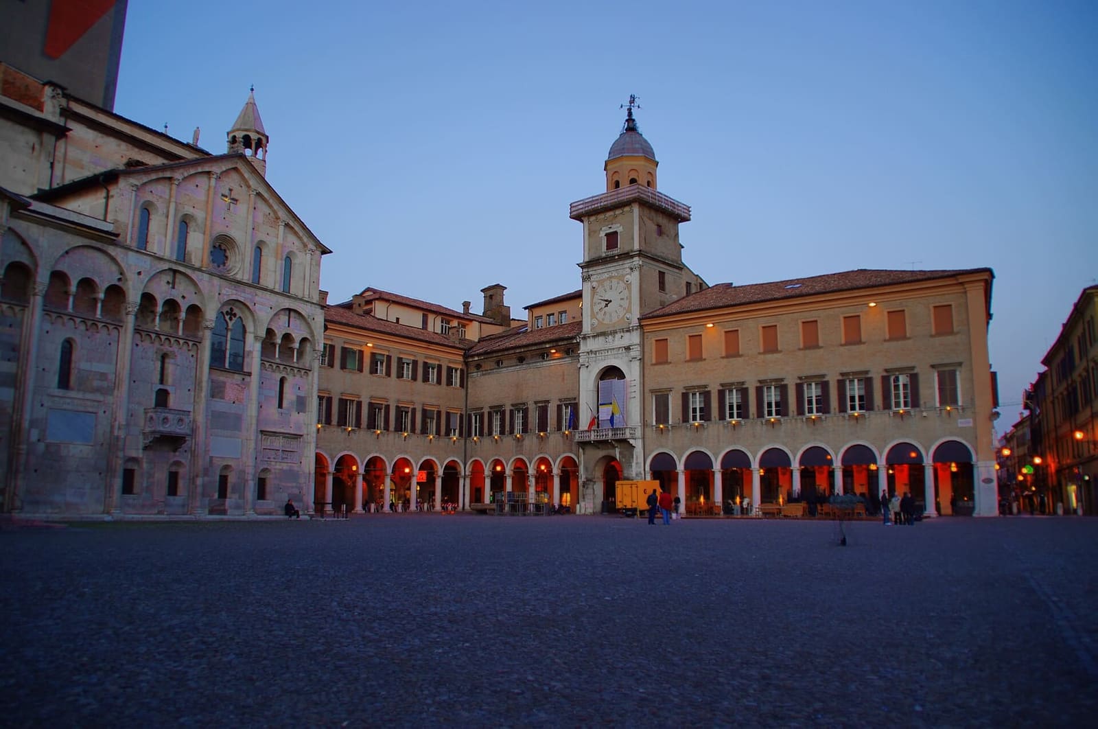 der Palazzo Comunale mit dem Uhrturm in der Abenddämmerung, neben der Fassade des Doms