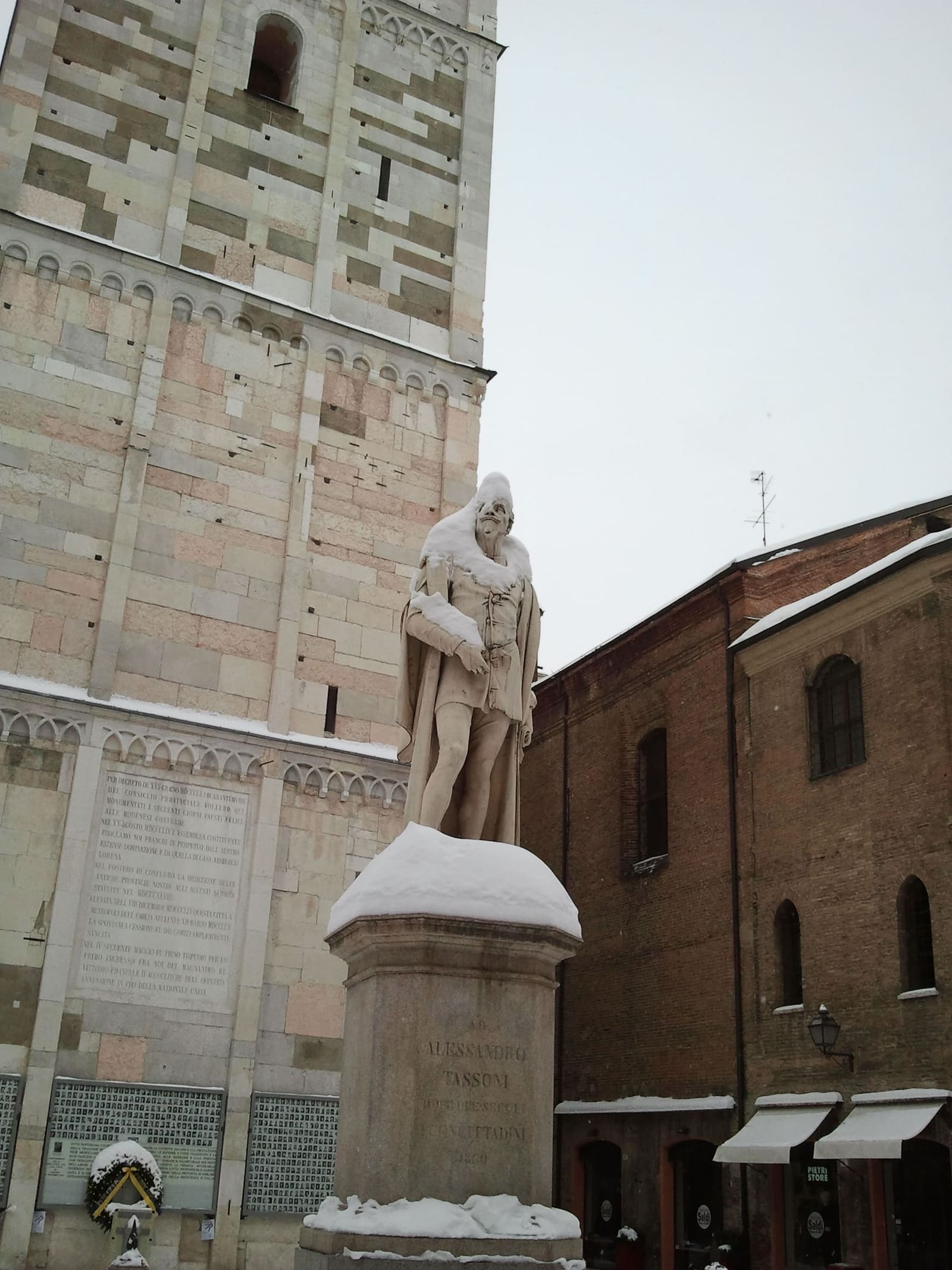 die Statue von Alessandro Tassoni im Schnee, am Fuß der Ghirlandina