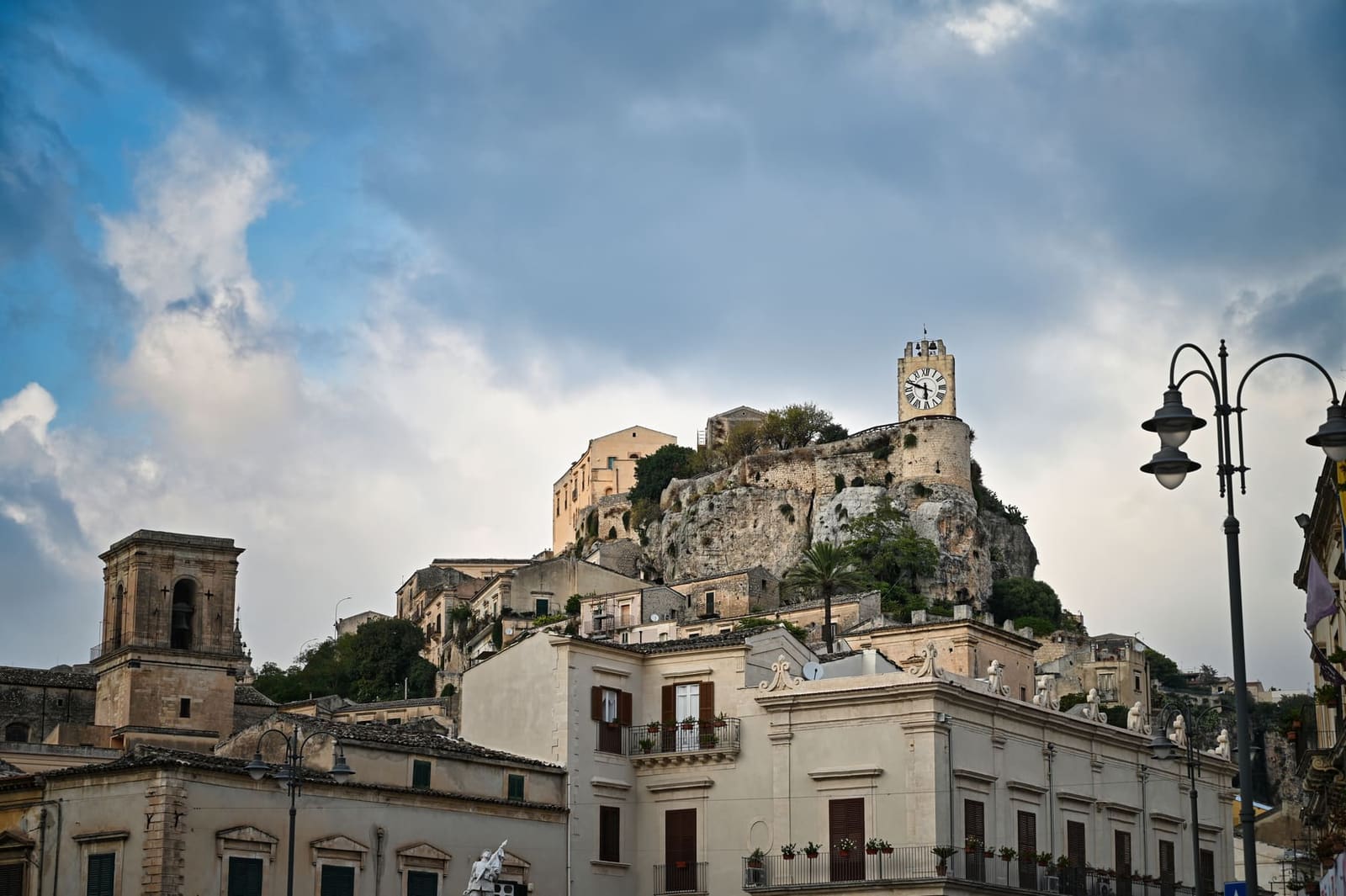 la rupe del castello dei Conti con la Torre dell'Orologio in cima, sopra i palazzi di Modica Bassa