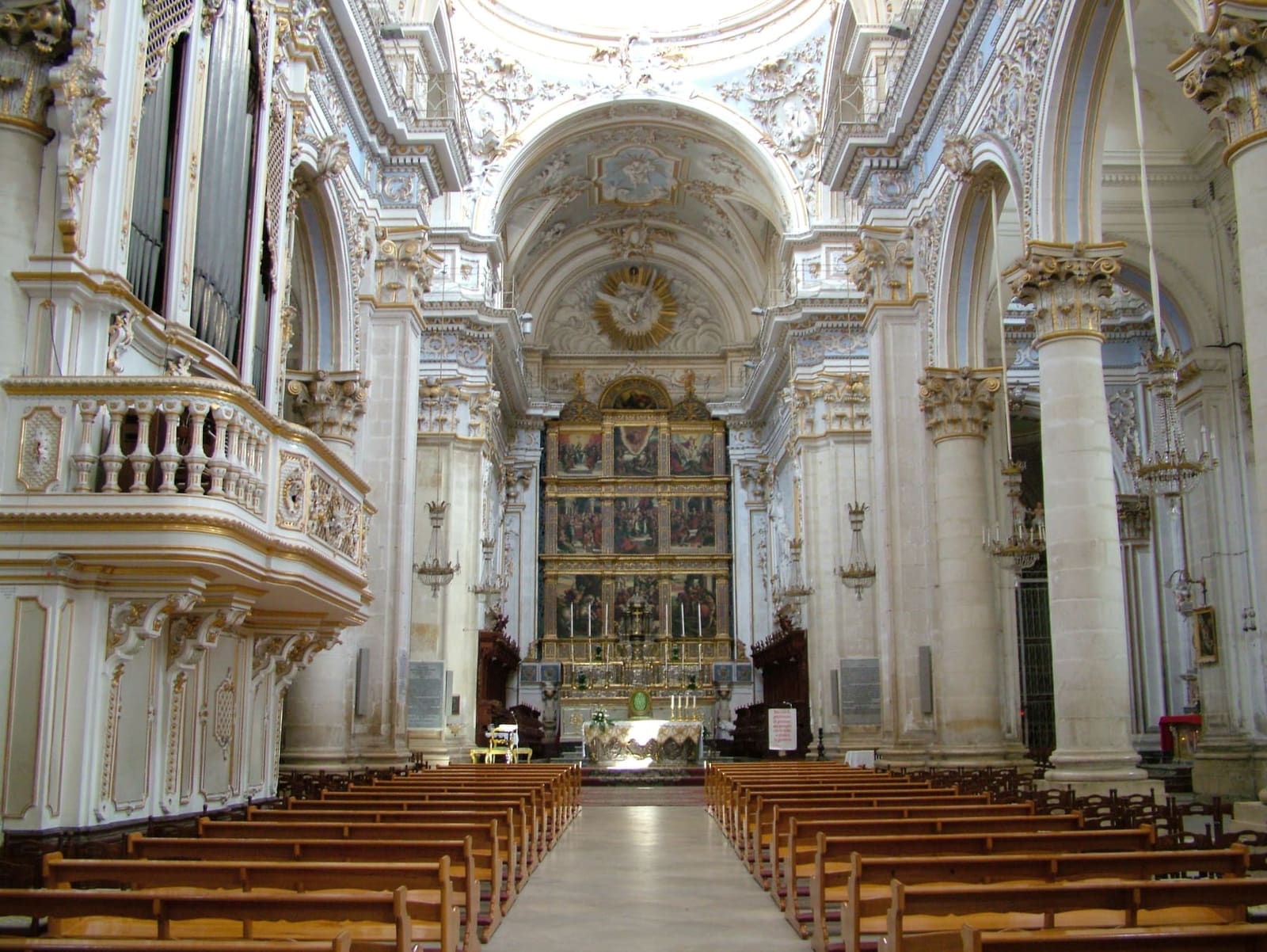 la navata centrale di San Giorgio, bianca e oro, con il polittico dietro l'altare
