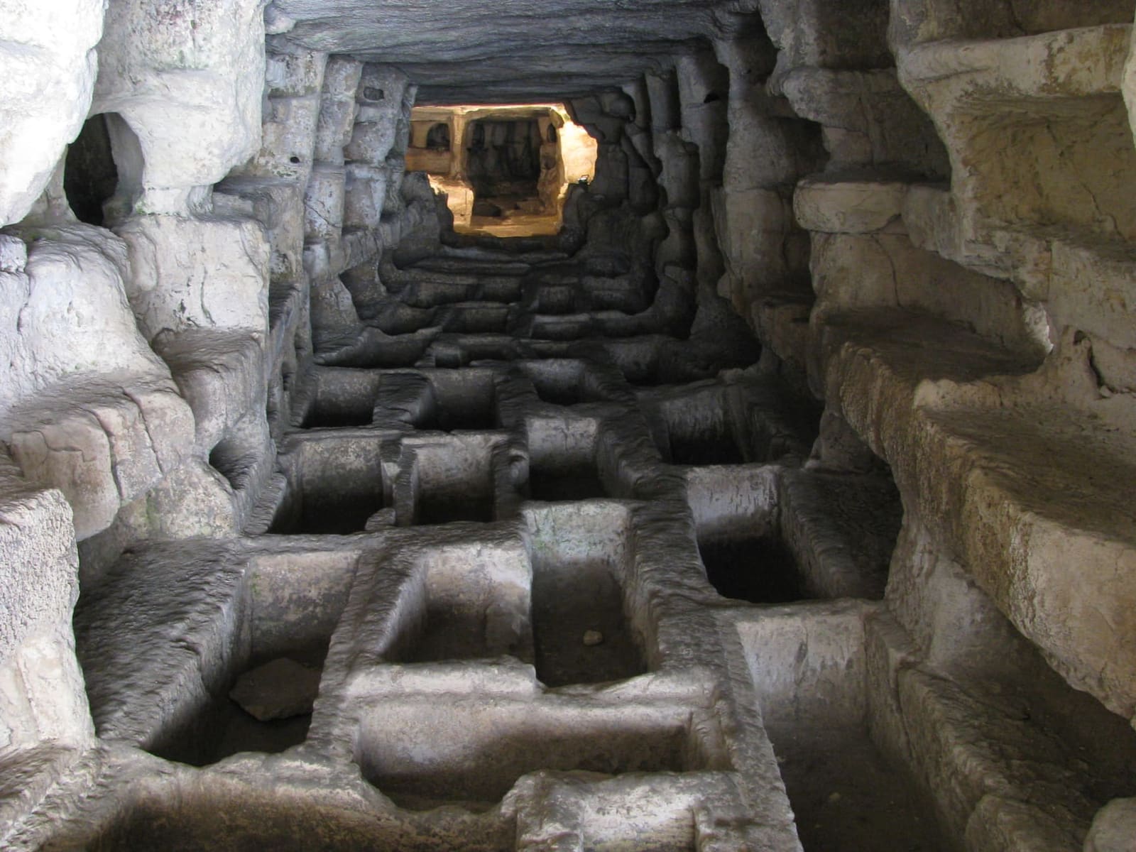 le tombe scavate nel pavimento di roccia di una galleria della Cava d'Ispica