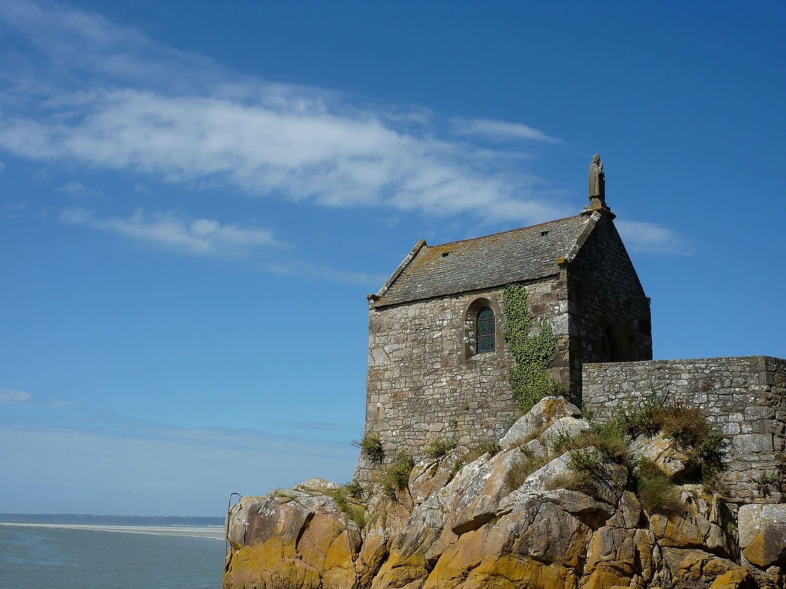 la chapelle Saint-Aubert sulle rocce ai piedi del Mont, sotto il cielo blu