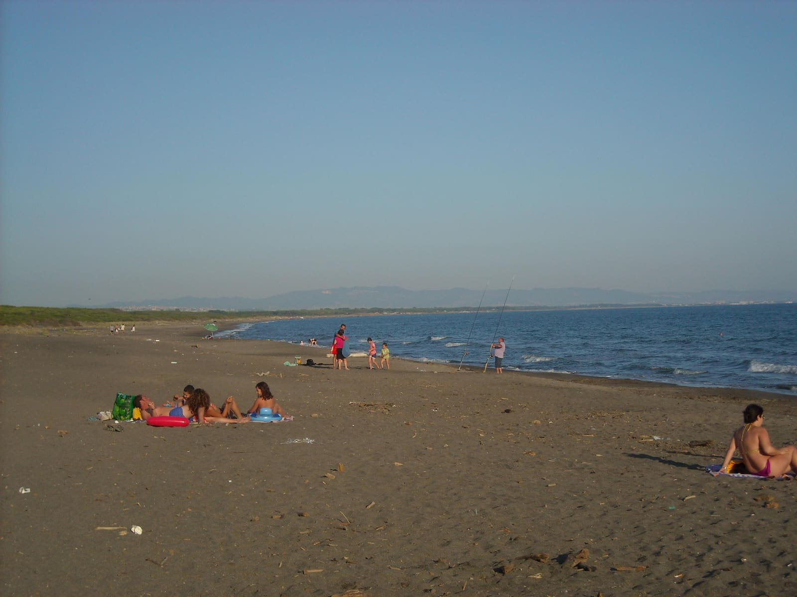 la spiaggia libera di Montalto Marina, larga e di sabbia scura, con le dune basse alle spalle e la costa che si allunga verso nord