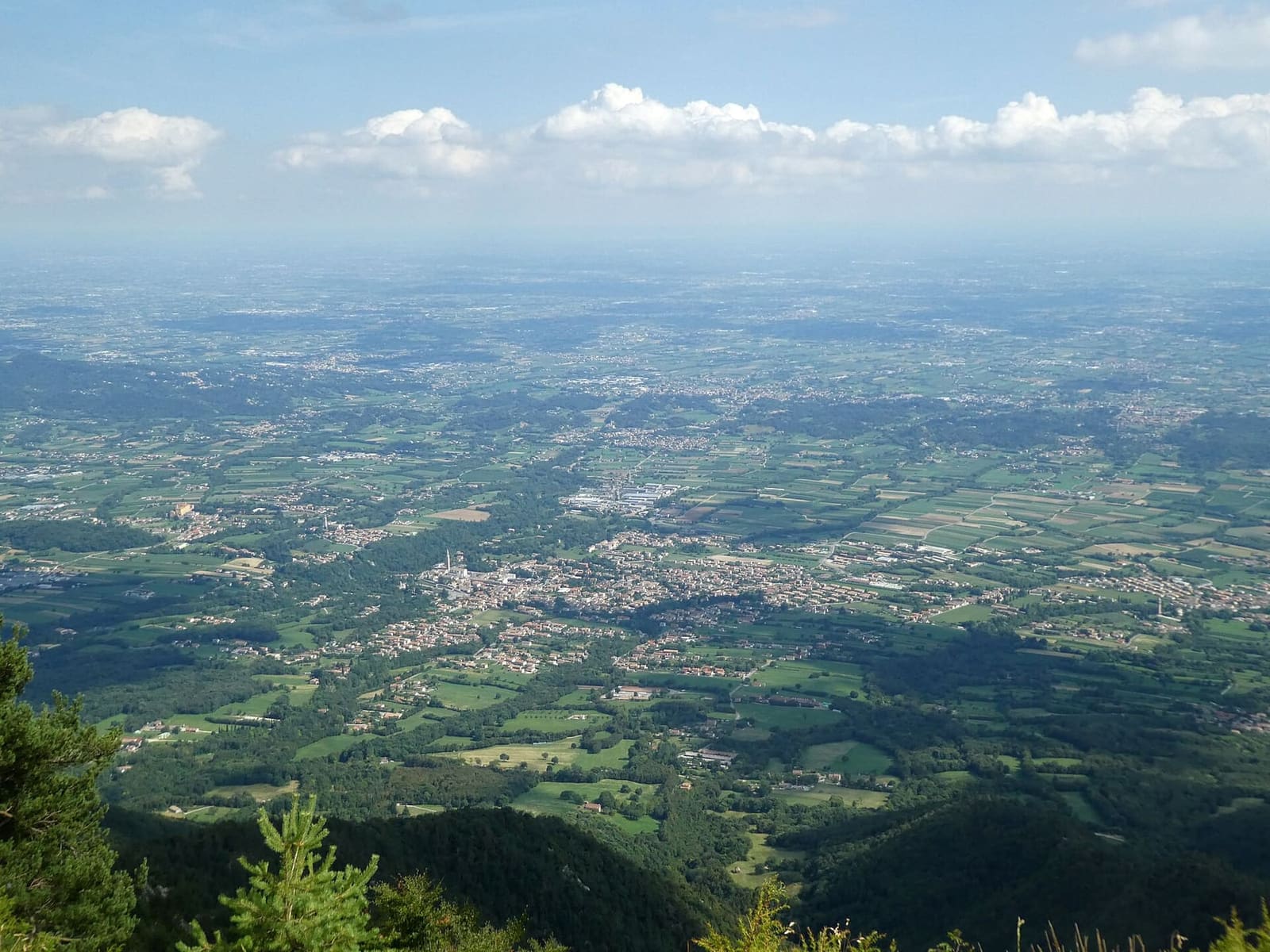 la pianura veneta vista dal Grappa, con i paesi della pedemontana sotto il bosco, a luglio