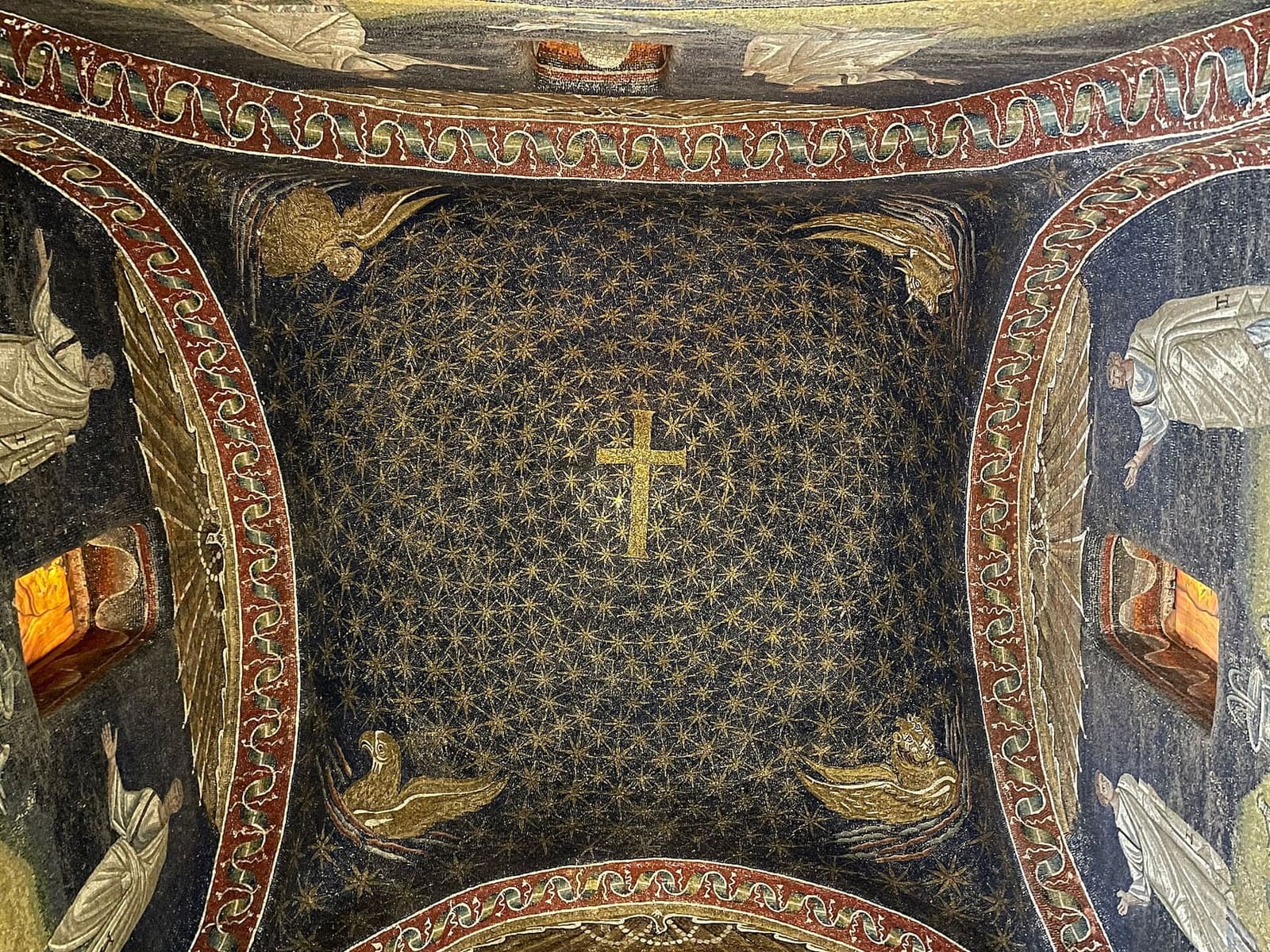 the starry sky of the dome of the Mausoleum of Galla Placidia with the gold cross and the symbols of the evangelists