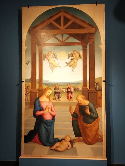 una natività della quadreria del Lia, dipinta sotto un portico con due angeli in volo e i pastori sullo sfondo